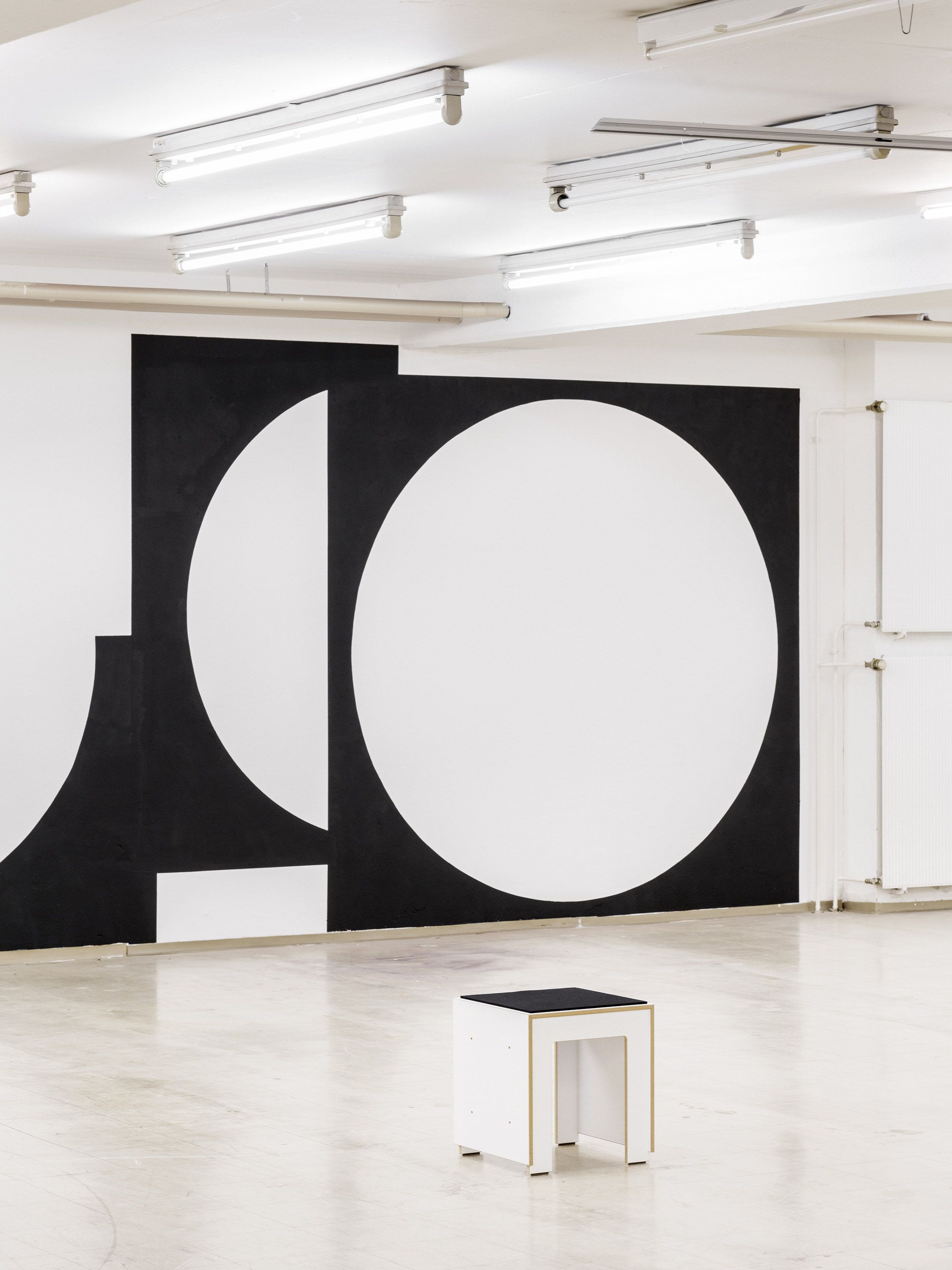 Solo exhibition wall graphic by Manuel Lorenz, black geometric shapes on white wall