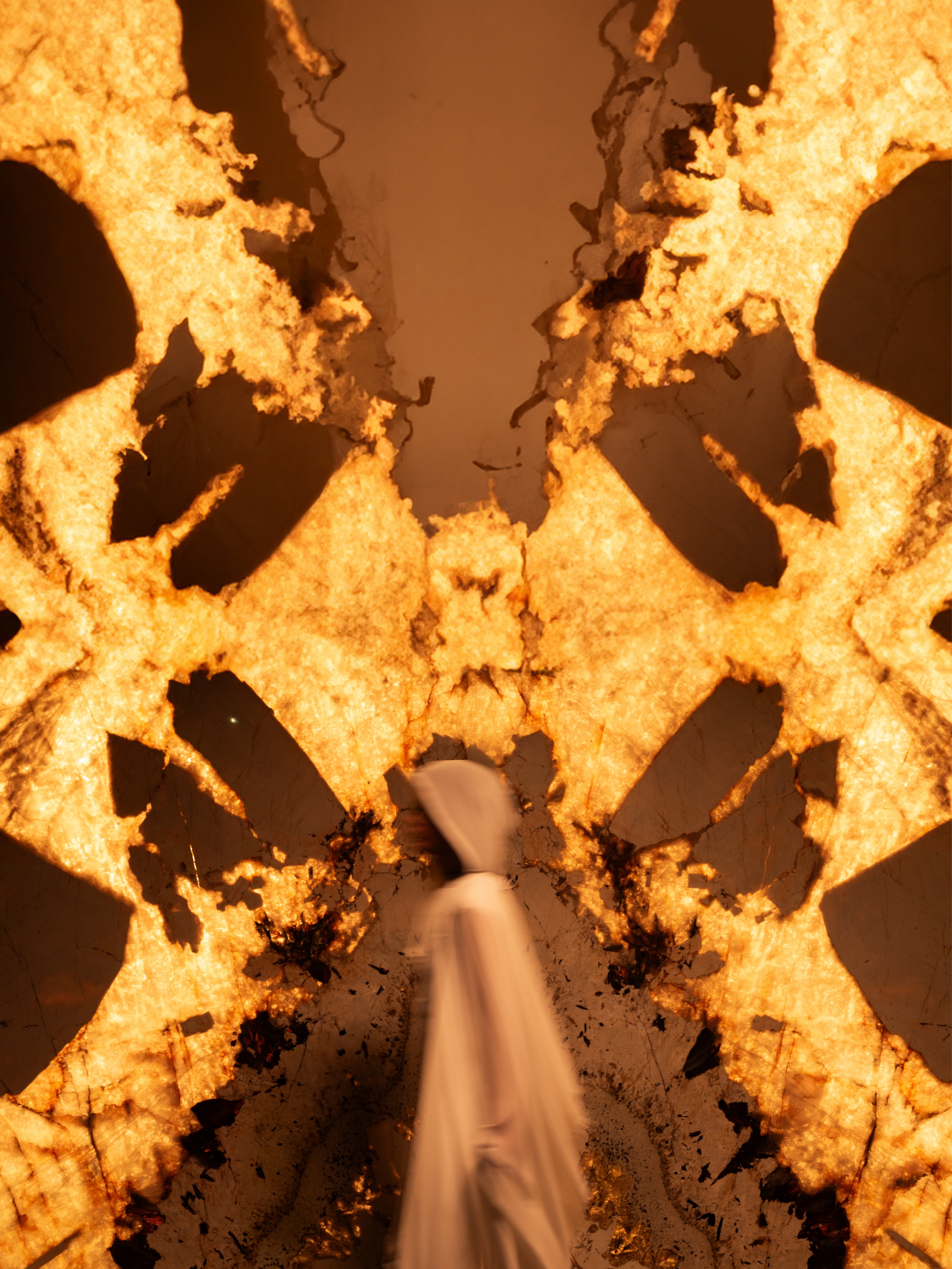 Italstone backlit amber onyx with hand and flowing fabric — Shot in Stone | BoldCrest