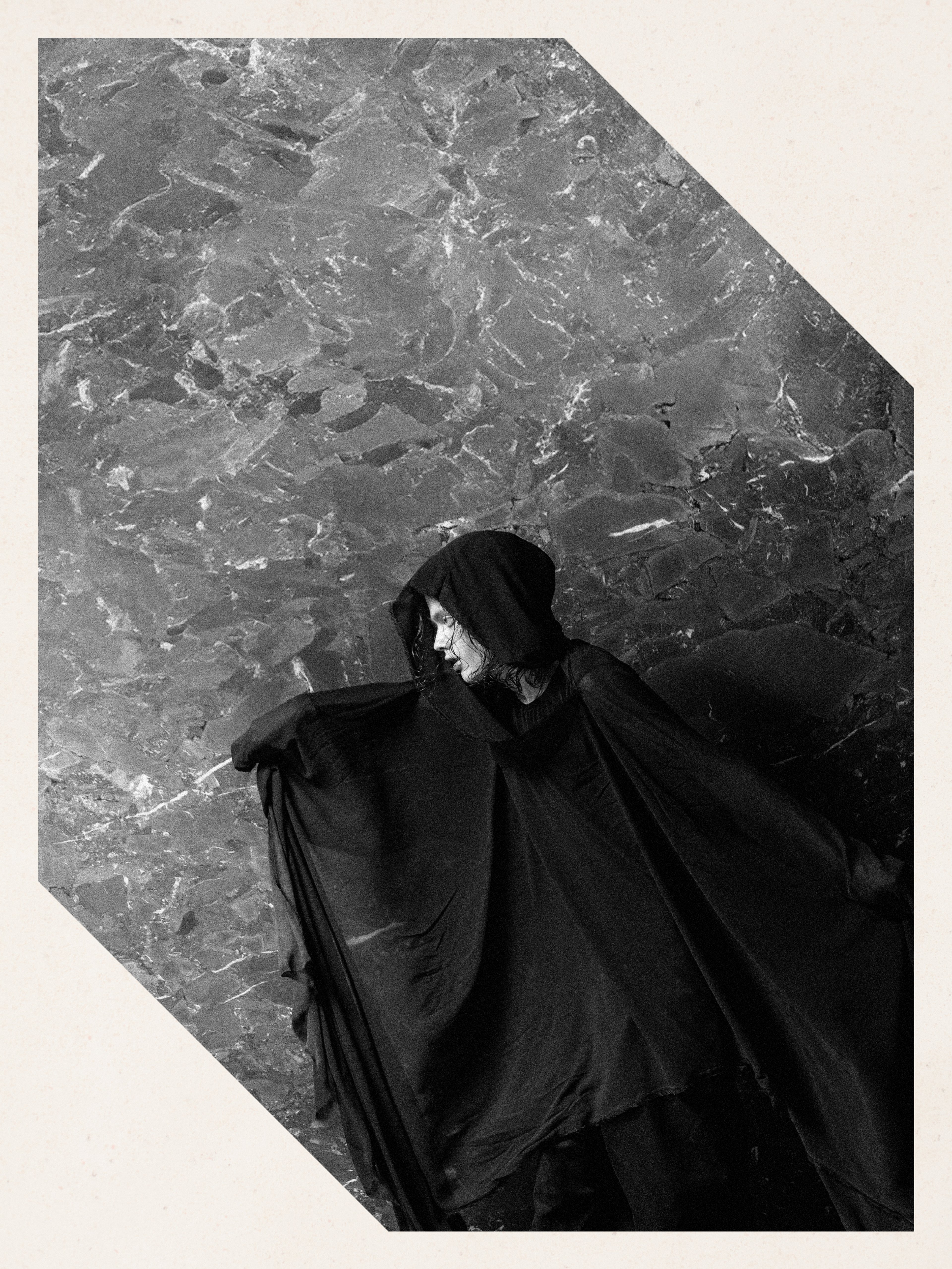 Italstone model in a black cloak on a grey marble slab — Shot in Stone | BoldCrest