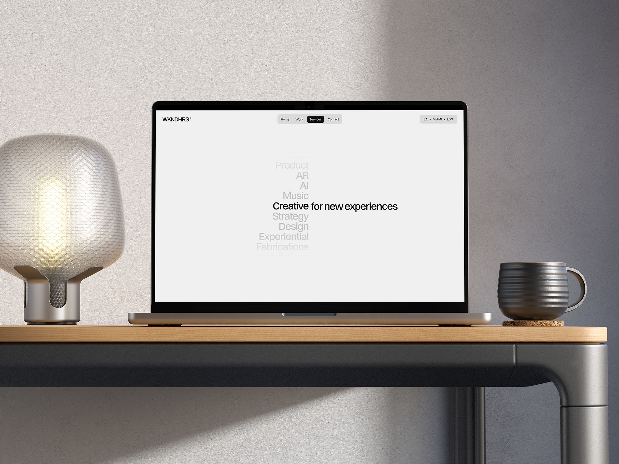 WKNDHRS creative studio website displayed on a laptop on a minimalist desk, showcasing a clean homepage with the message “Creative for new experiences”