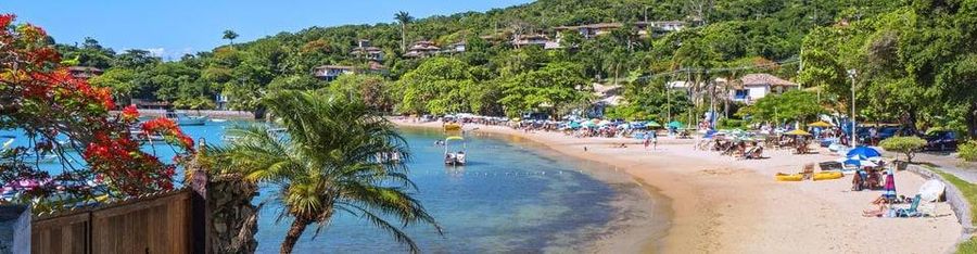 Playa de Búzios con sombrillas y vegetación tropical