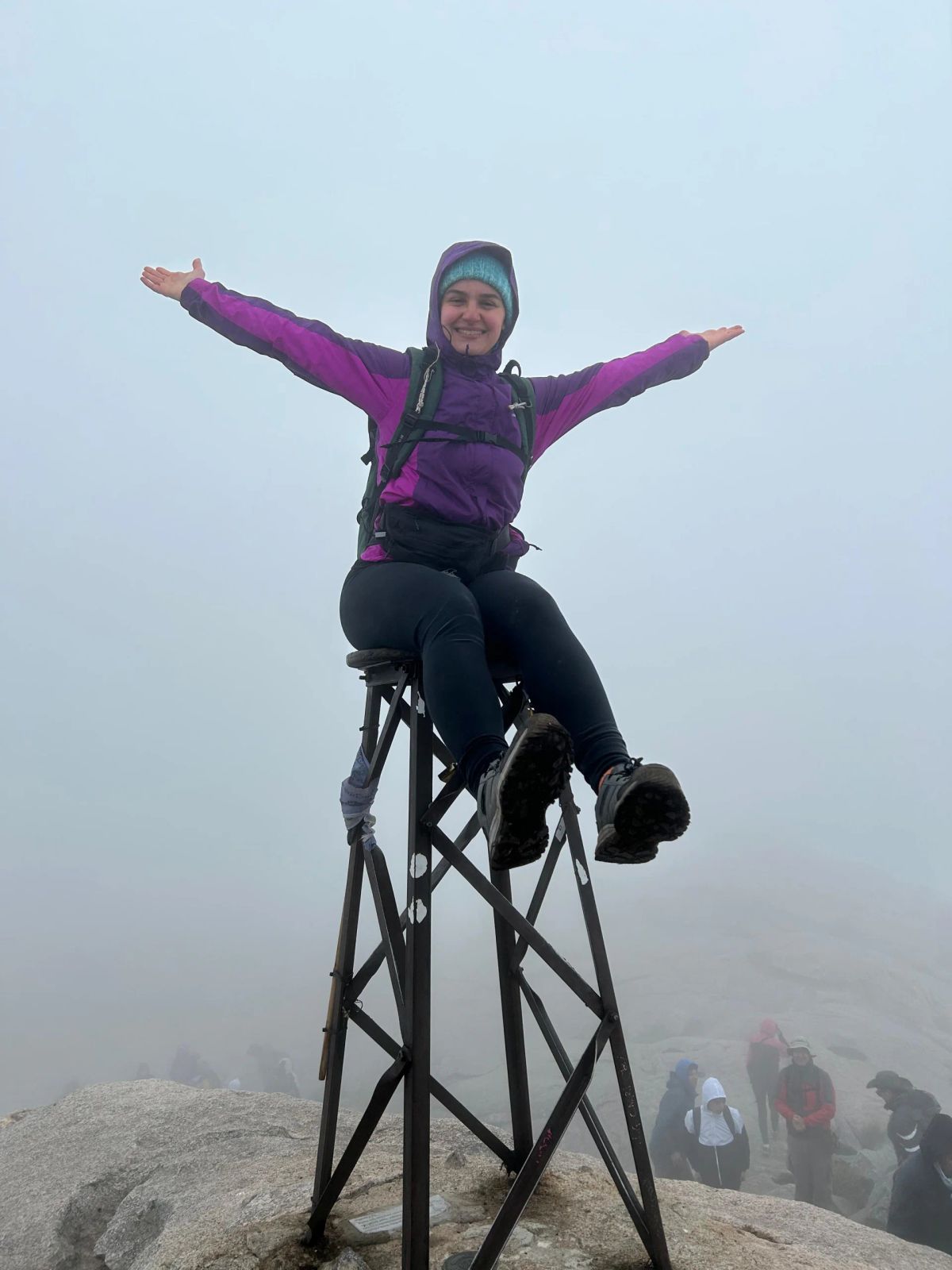 Trekker con los brazos abiertos en la cumbre del Champaquí rodeada de niebla