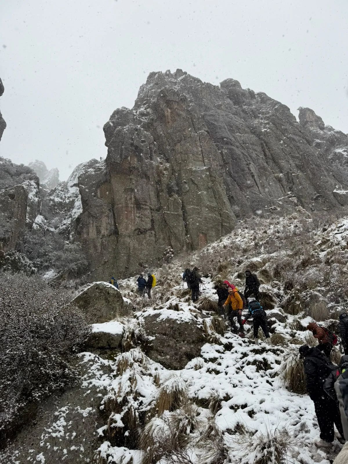 Mogote de granito nevado con el grupo subiendo por la ladera de Los Gigantes
