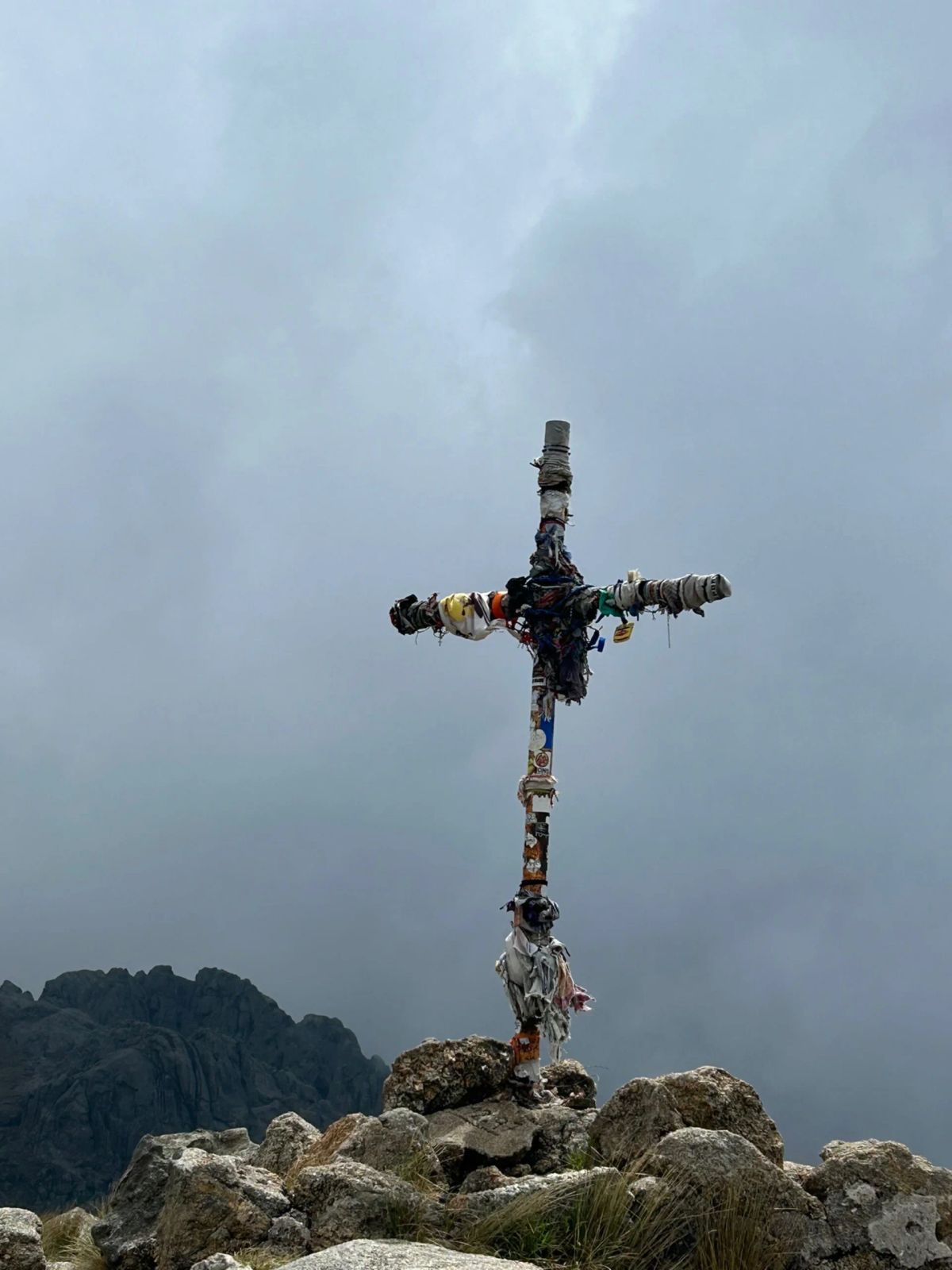 La cruz cumbrera de Los Gigantes recortada contra las nubes bajas de la sierra