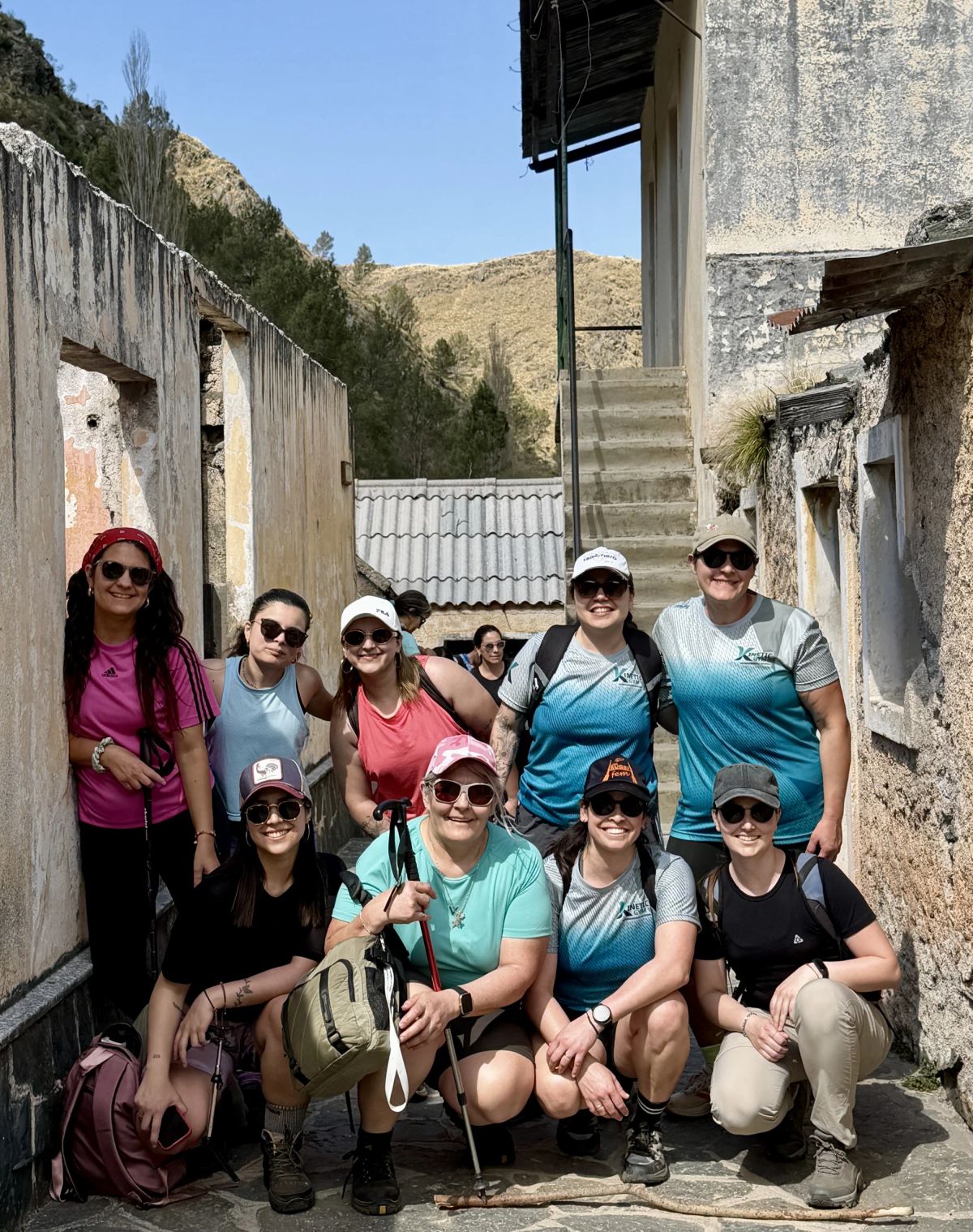Grupo de trekkers de Mons junto a las paredes de piedra de las construcciones abandonadas