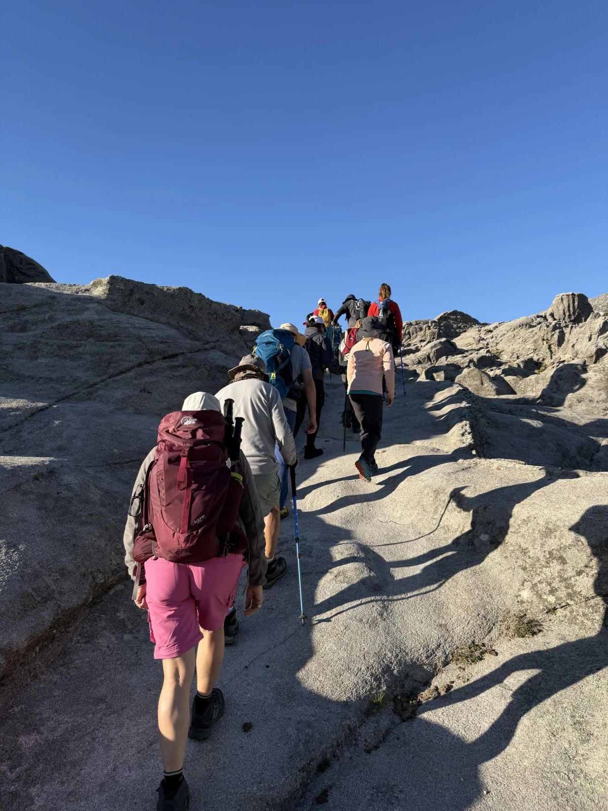 Trekkers subiendo por las lajas de granito en el tramo final hacia la cumbre del Champaquí