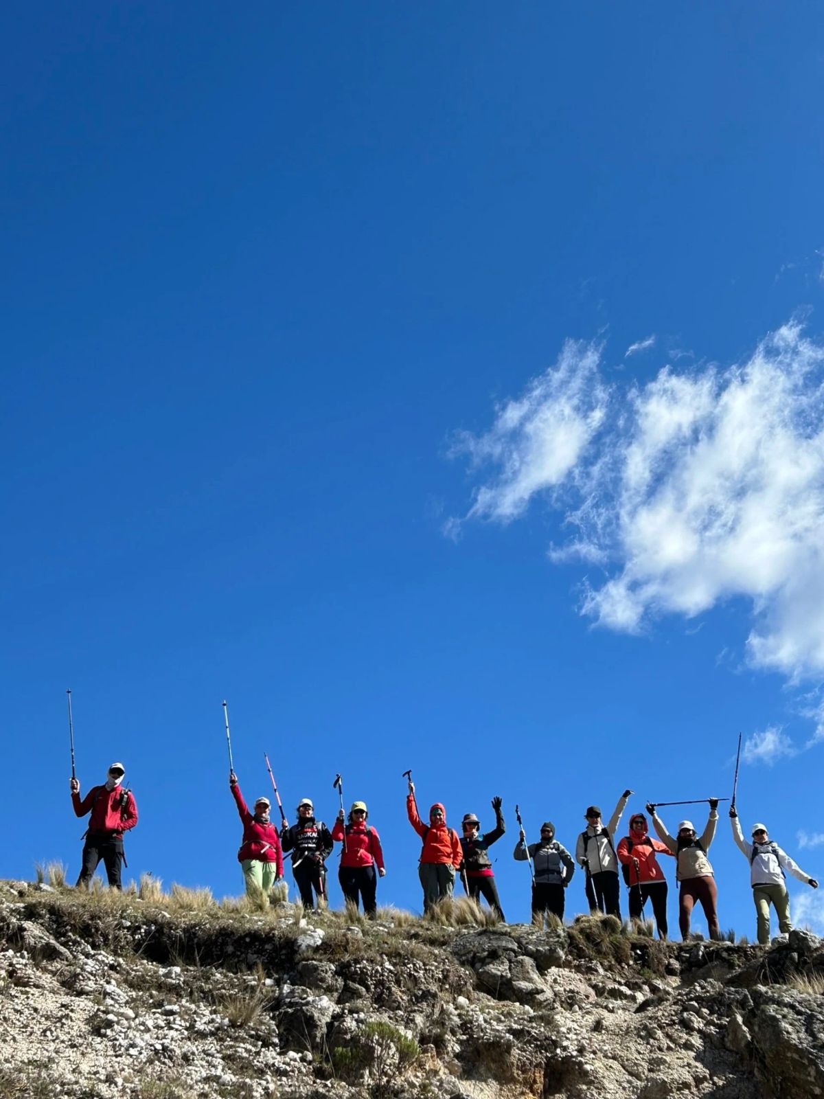 El grupo de Mons con los brazos en alto sobre el filón, bajo el cielo despejado de las sierras