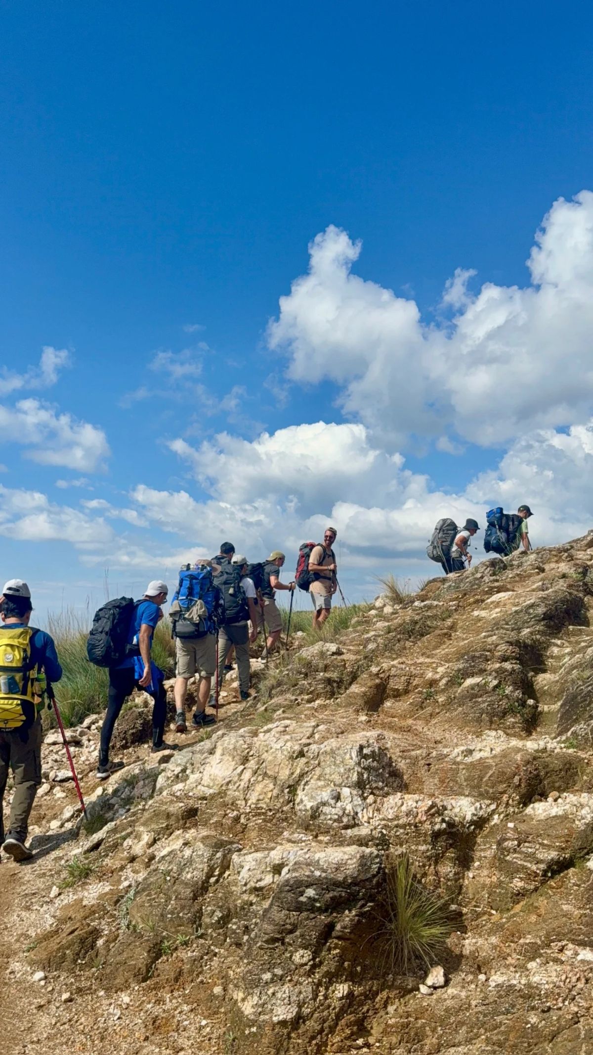 Trekkers superando un tramo de roca en el ascenso al Cerro Champaquí, Córdoba