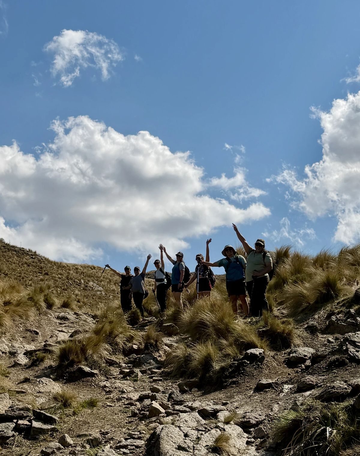 Trekkers en el filón rocoso con las nubes de primavera sobre la sierra