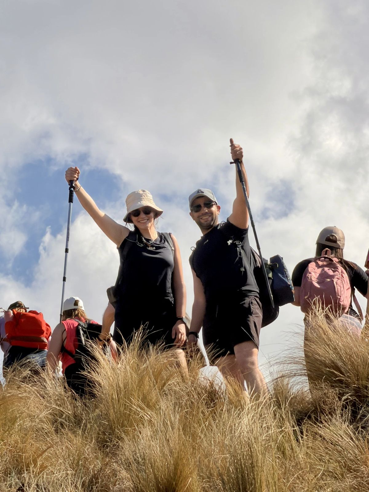Participantes celebrando con los bastones en alto entre los pajonales de la sierra