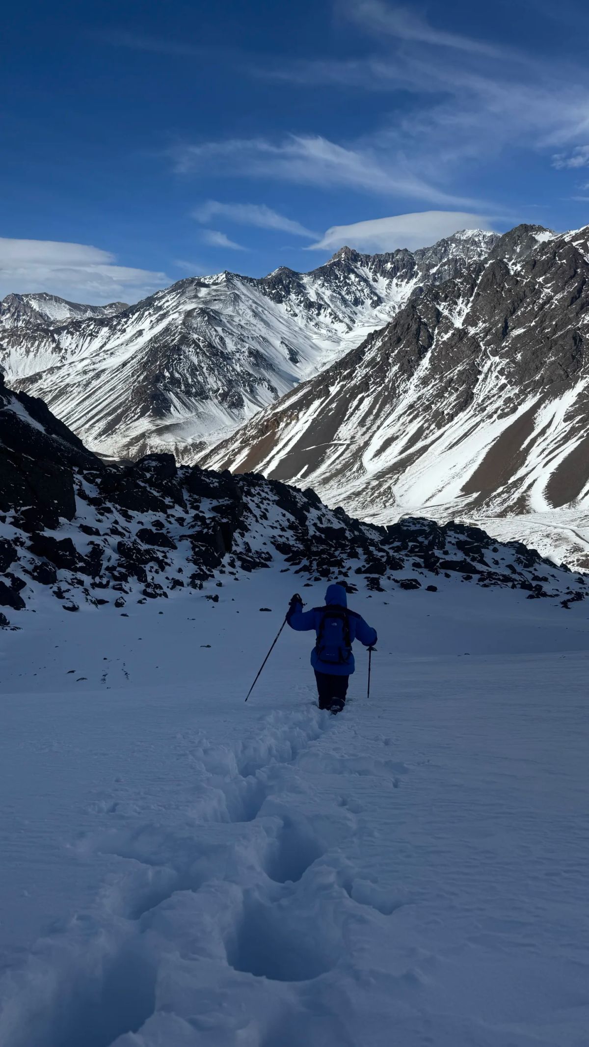 Panorámica del valle nevado de la Alta Montaña de Mendoza con un montañista diminuto en la inmensidad