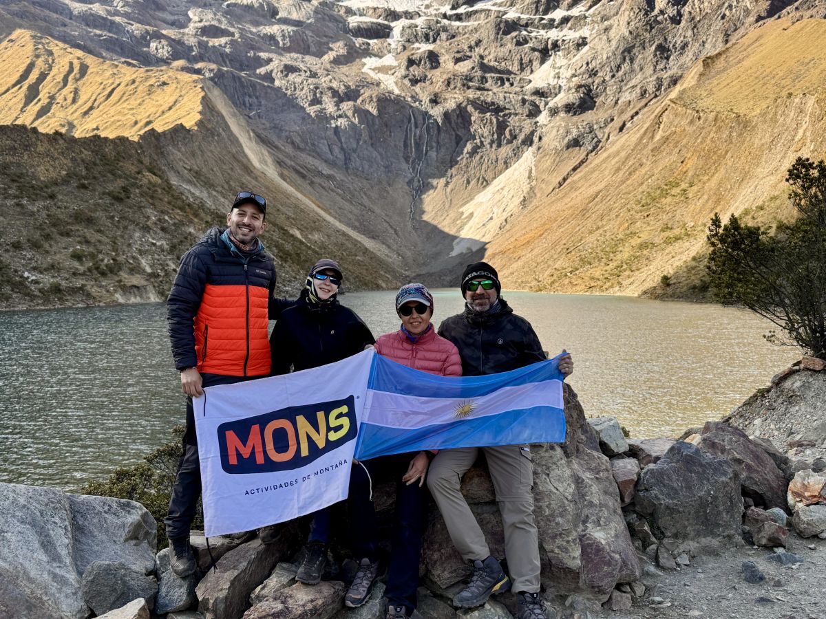 El grupo con la bandera de Mons frente a la laguna Humantay