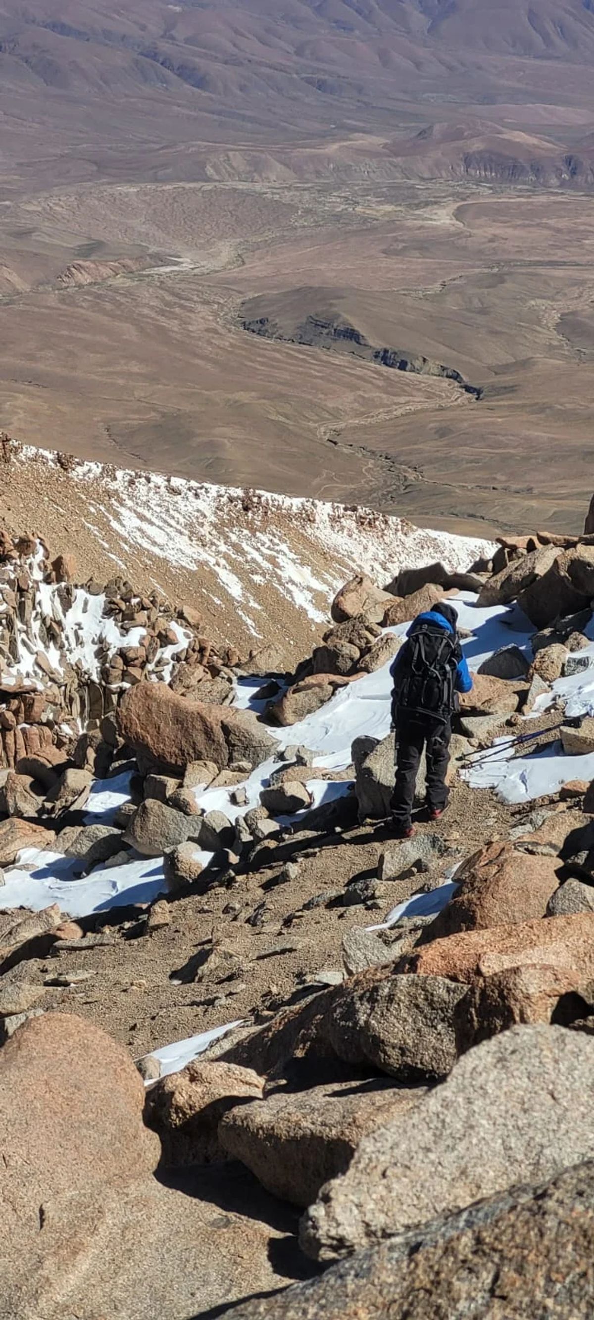 Andinista superando un tramo de roca durante la aproximación al Nevado de Chañi