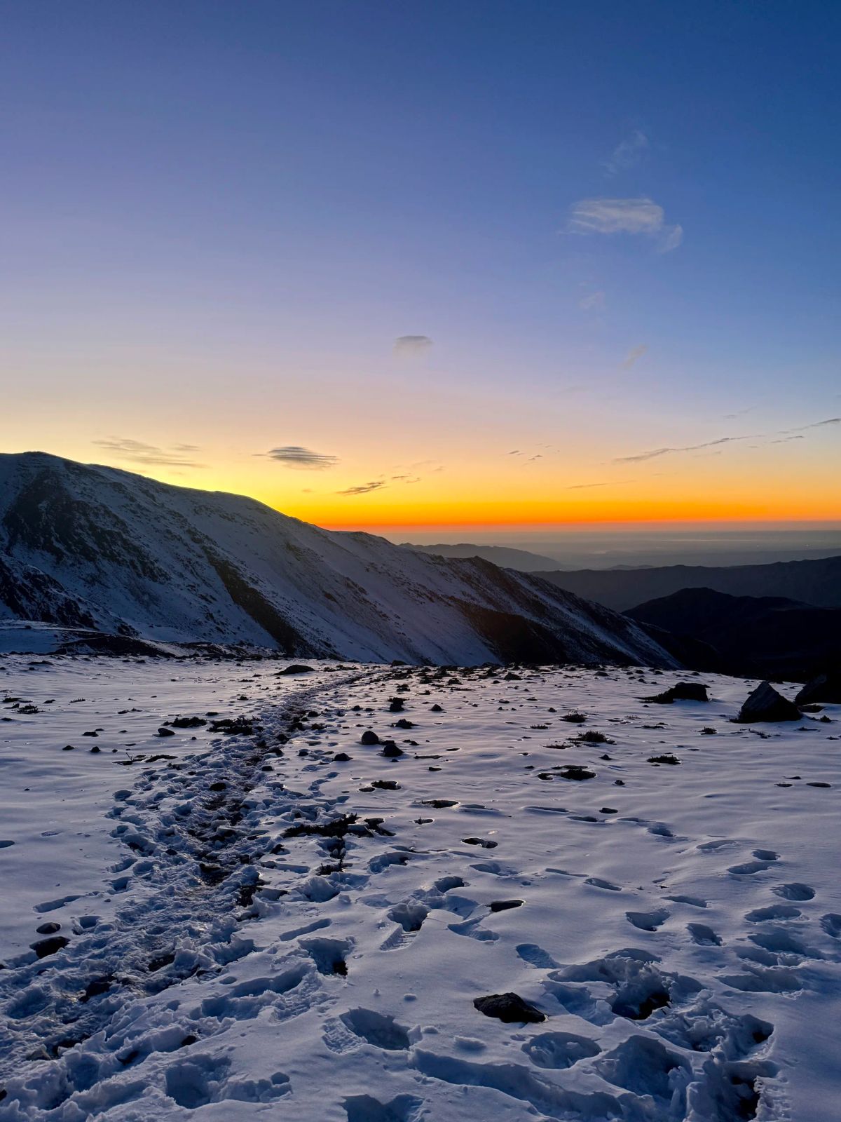 Primeras luces del amanecer sobre la nieve durante el ascenso al Cerro del Medio