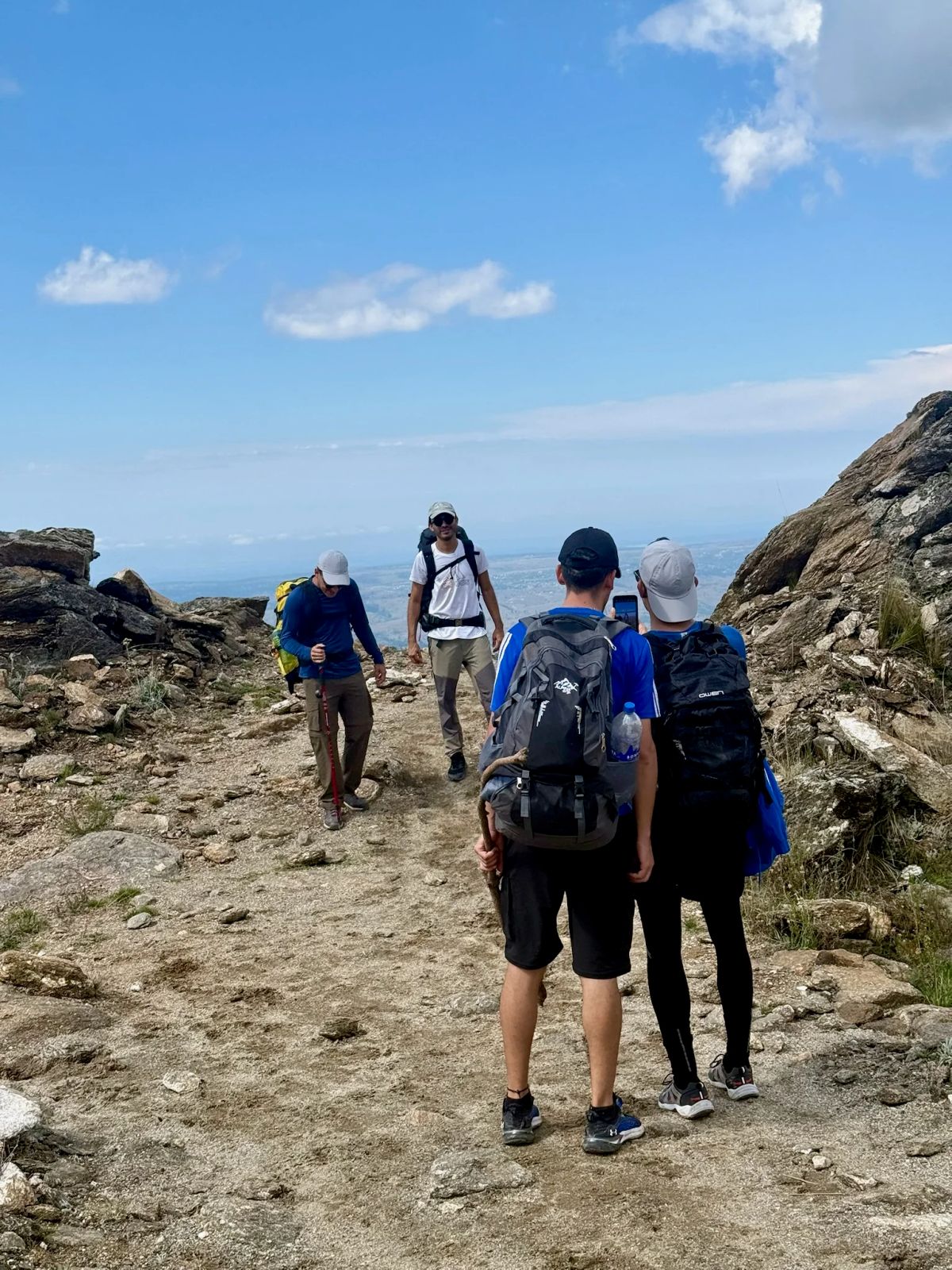 Caminantes avanzando por el sendero de piedra en el tramo final hacia la cumbre del Cerro Champaquí