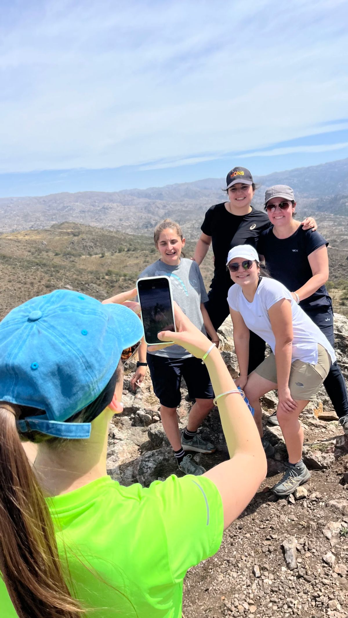 Una chica fotografiando al grupo en la cumbre durante el trekking familiar en Alpa Corral