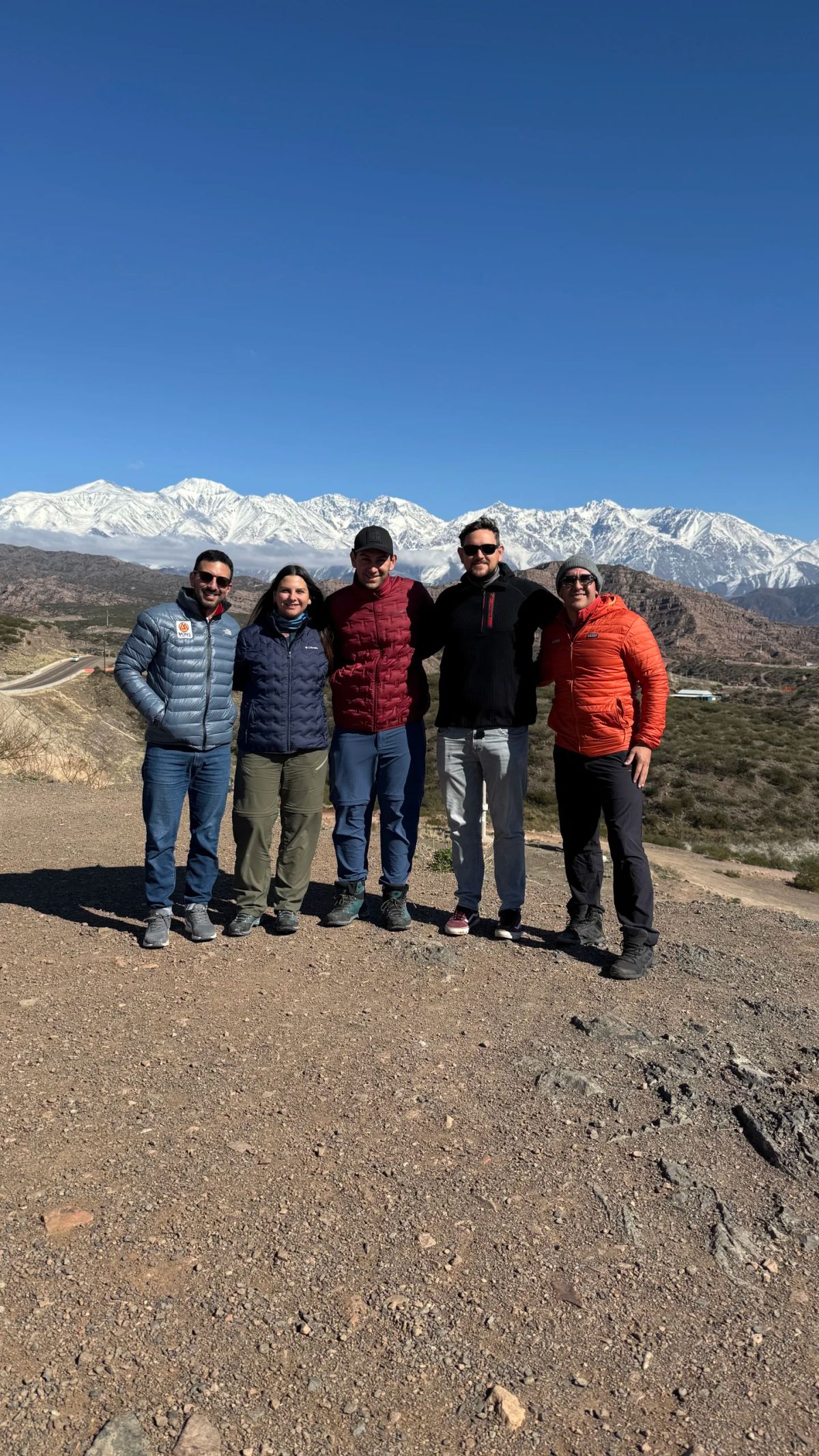 El grupo posando junto al camino de altura con el Cordón del Plata nevado de fondo