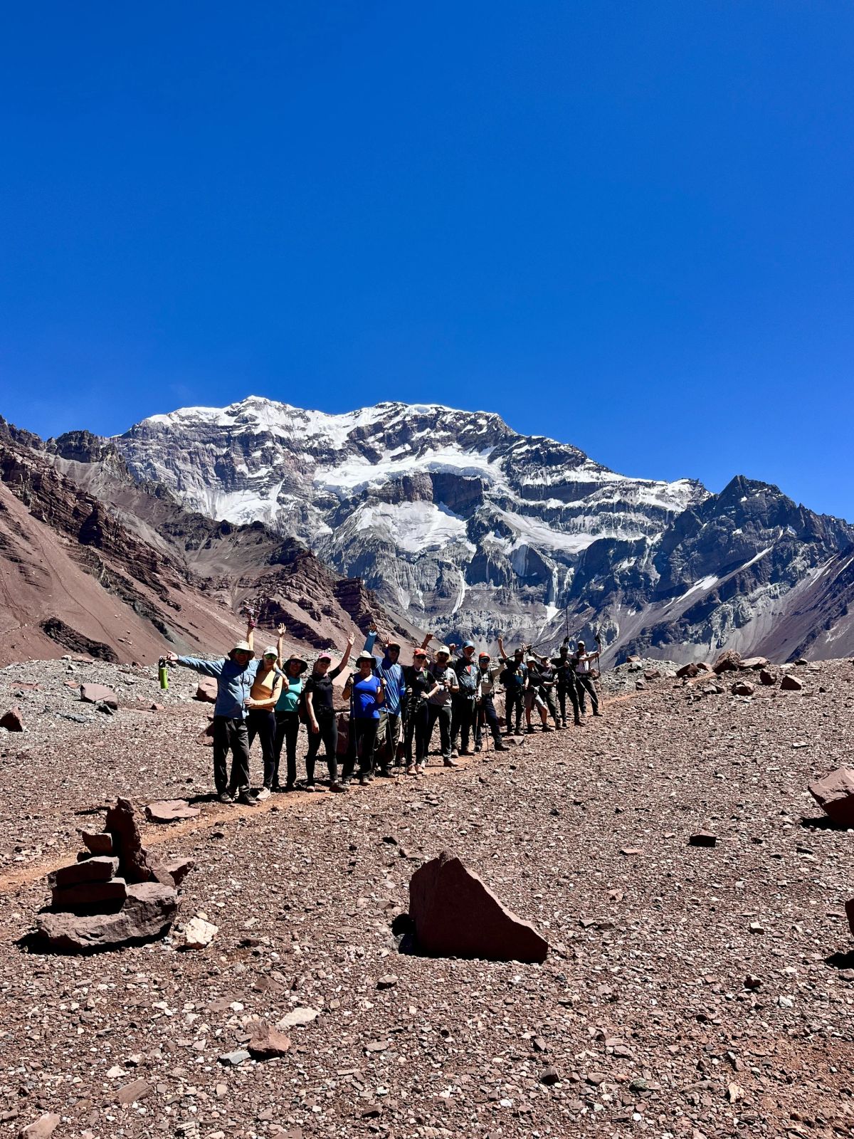 El grupo de Mons caminando frente a la pared sur del Aconcagua