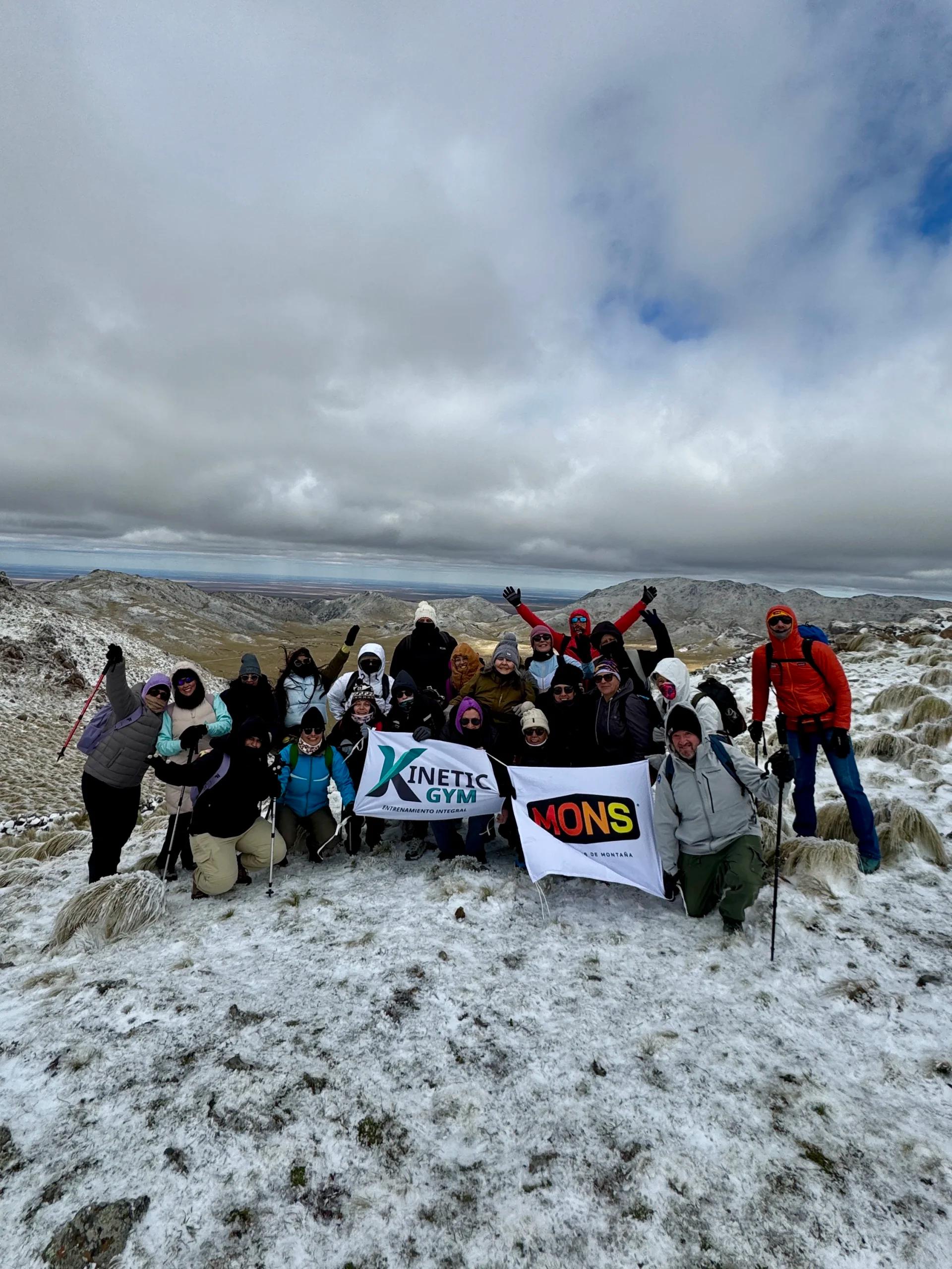 El contingente con los brazos en alto y la bandera del grupo en la cumbre del Cerro El Morro