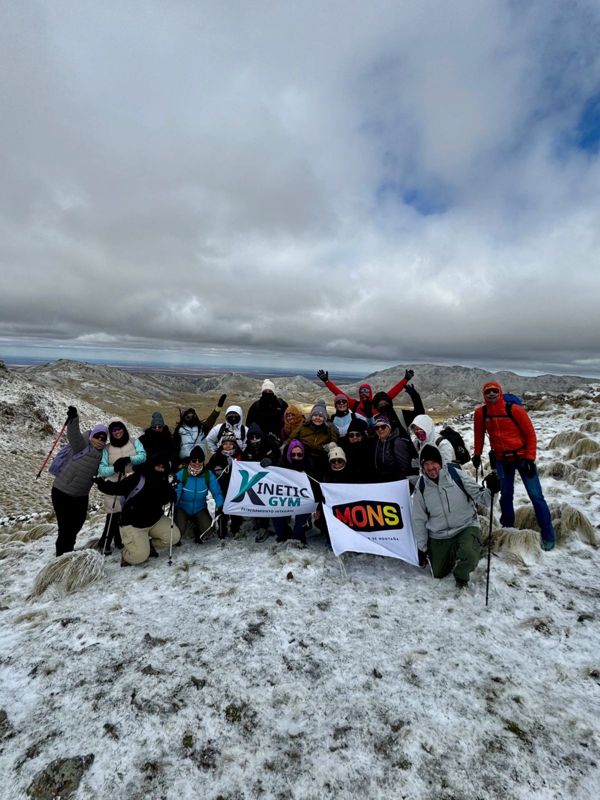 El contingente con los brazos en alto y la bandera del grupo en la cumbre del Cerro El Morro