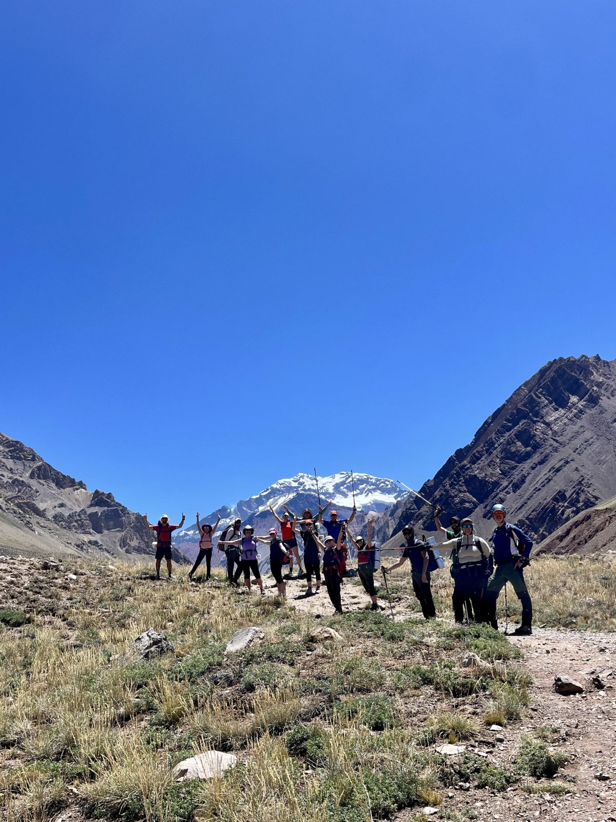Fila de trekkers avanzando por el sendero del valle rumbo a Plaza Francia
