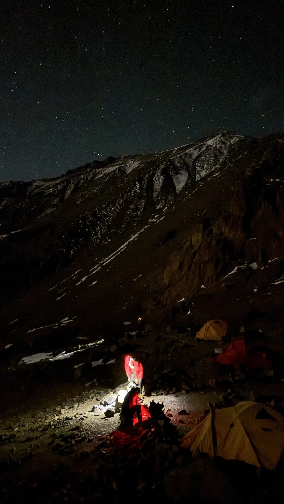 Carpas iluminadas de noche en el campamento de altura del Cerro El Plata