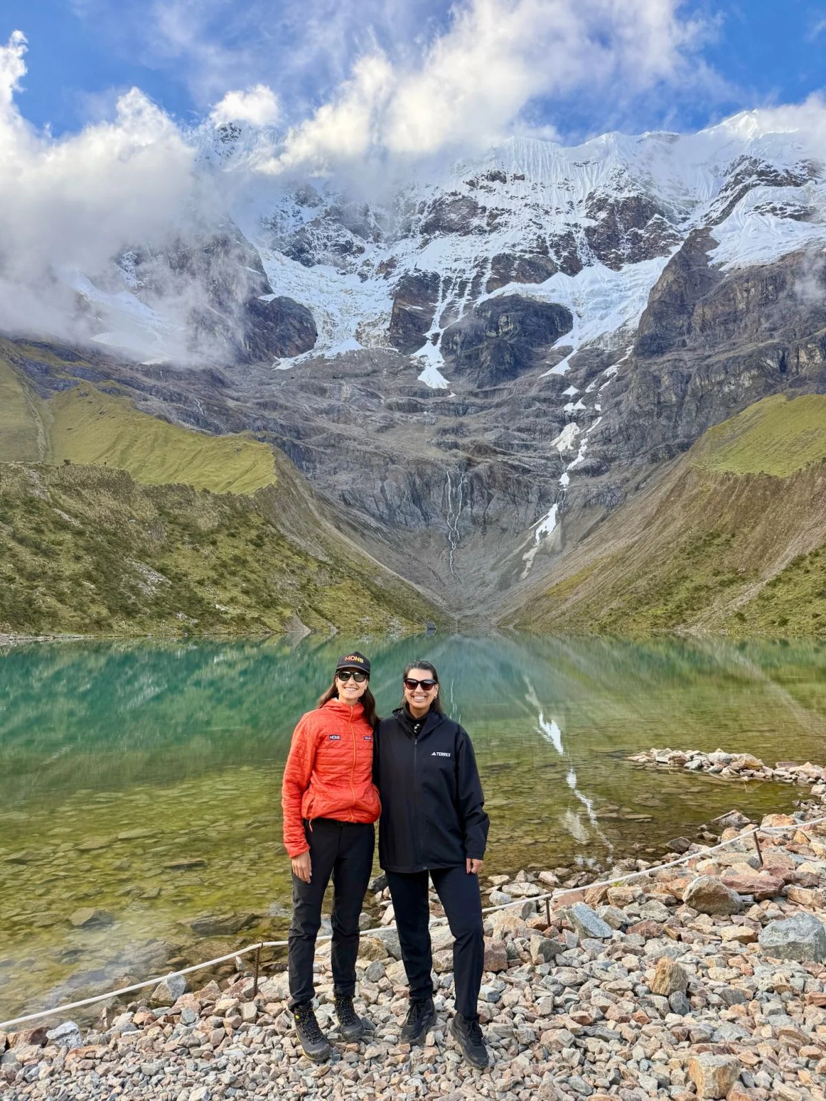 Dos trekkers frente a la laguna Humantay y el glaciar del Salkantay