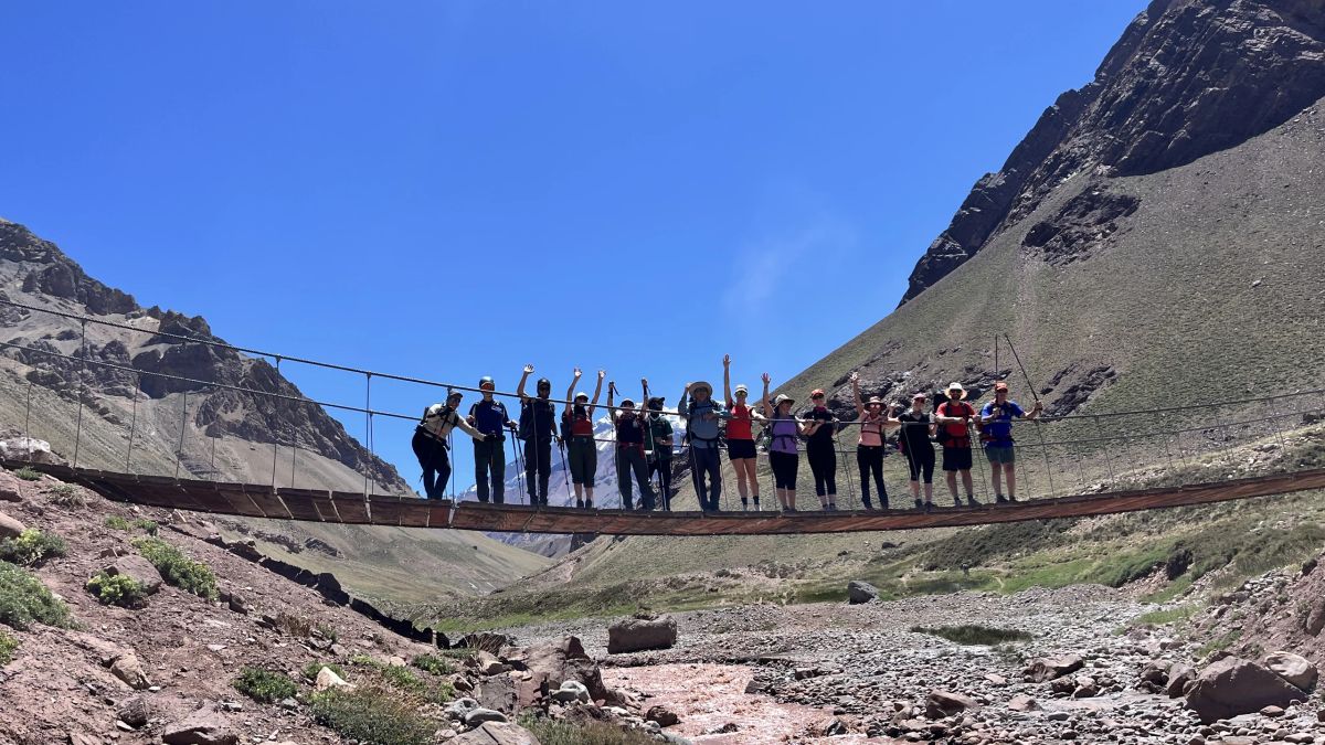El contingente cruzando el puente colgante sobre el río Horcones, Parque Aconcagua