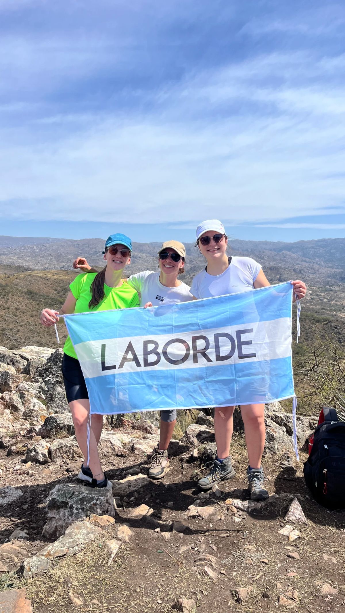 Participantes desplegando una bandera en la cumbre de los cerros de Alpa Corral, Córdoba