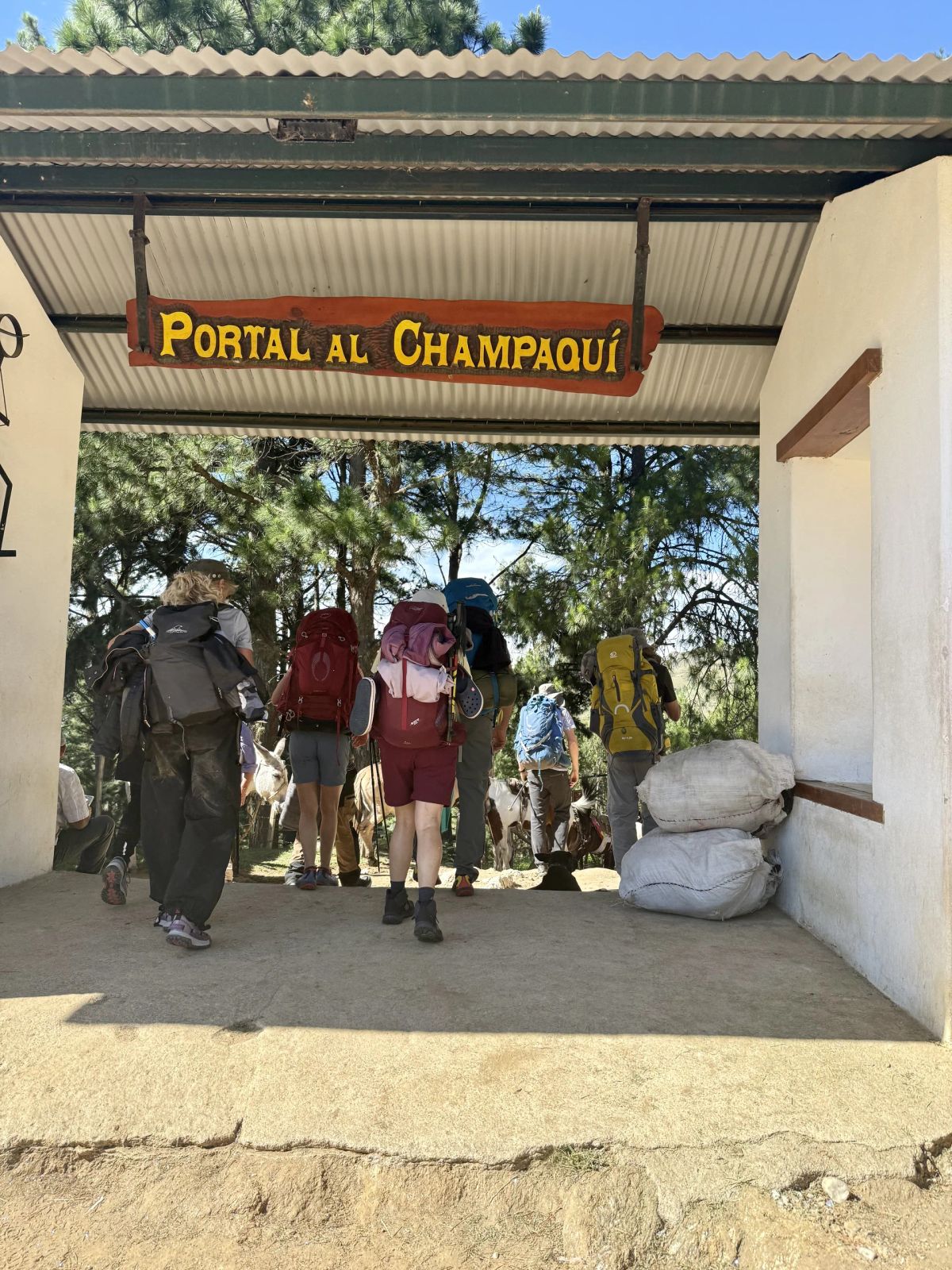 Trekkers cruzando el Portal al Champaquí en Villa Alpina, inicio del trekking de tres días