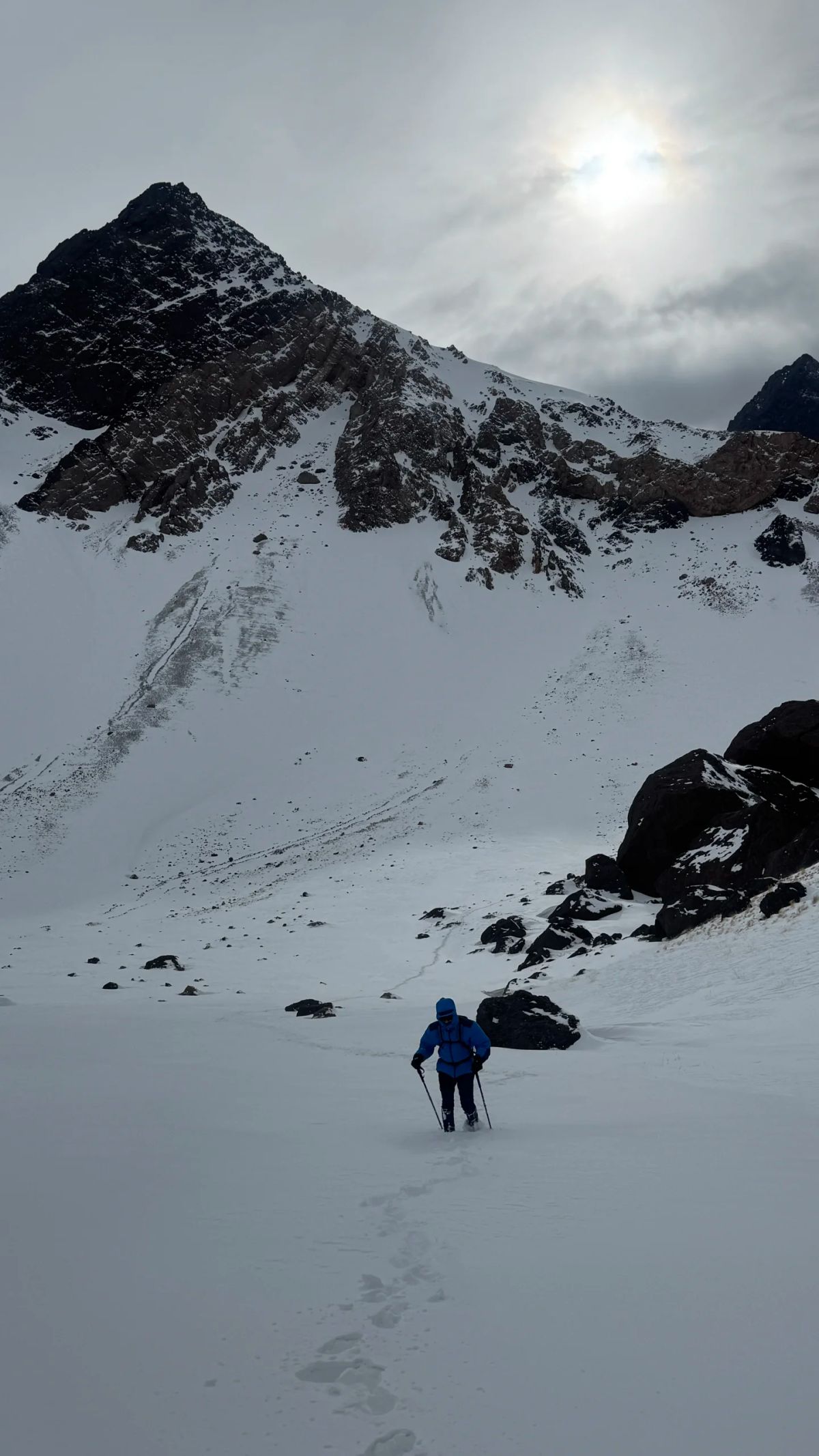 Montañista descendiendo hacia el valle con la luz de la tarde de invierno en la Cordillera de los Andes