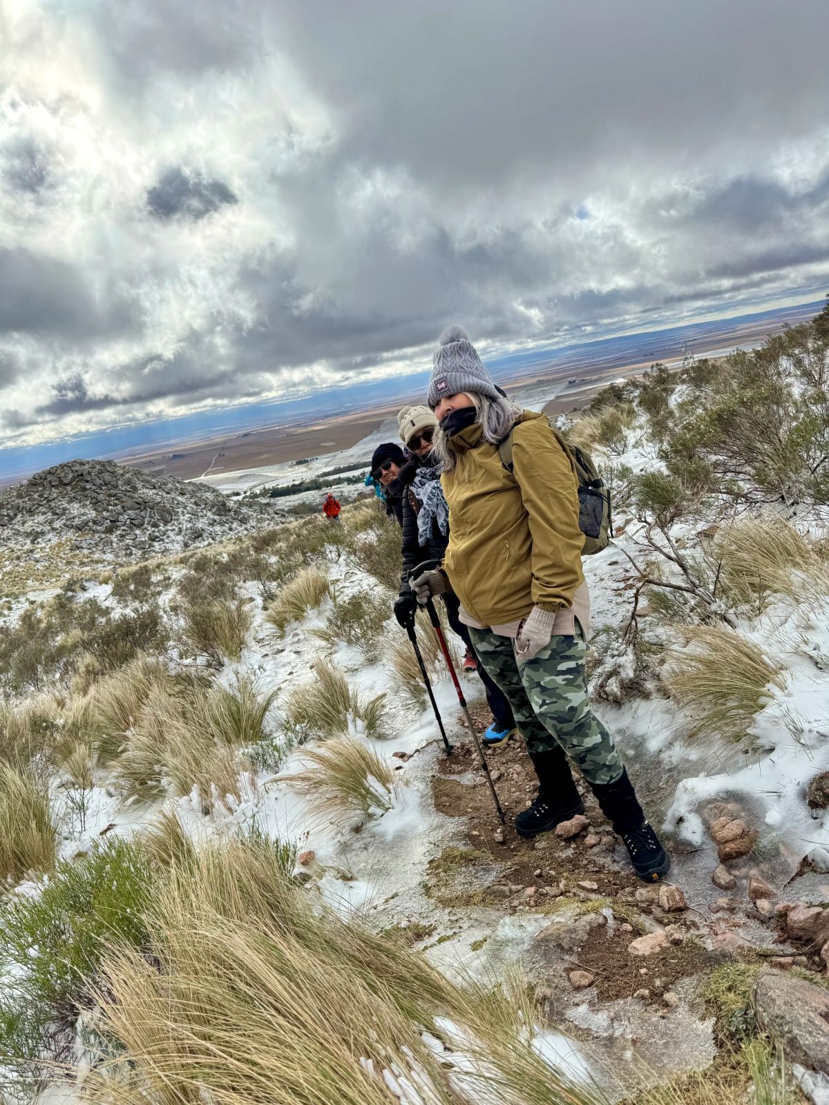 Trekker subiendo entre pajonales cubiertos de nieve en el Cerro El Morro