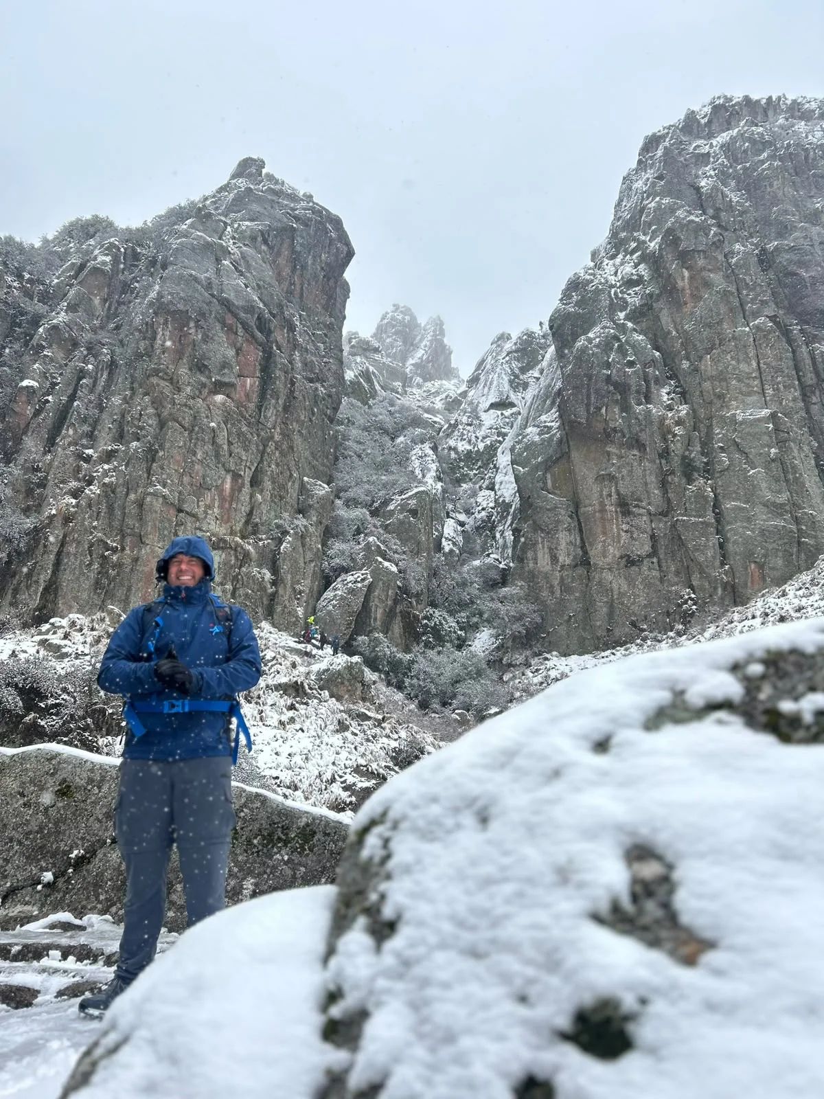 Trekker de Mons sobre la nieve al pie de las paredes de granito de Los Gigantes