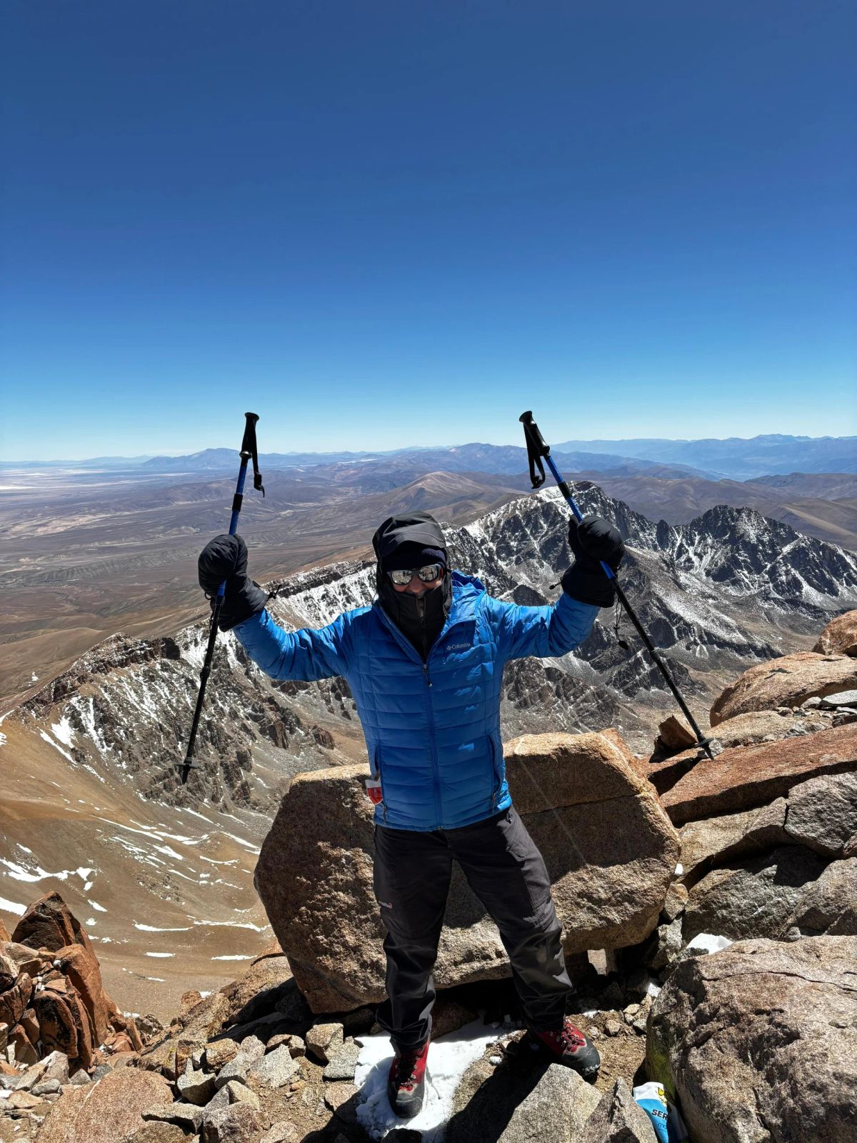 Andinista de Mons con los bastones en alto en la cumbre del Nevado de Chañi, 5.896 m.s.n.m.