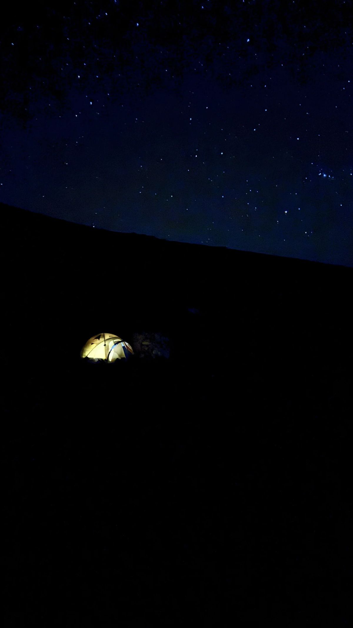 Carpa iluminada bajo el cielo estrellado en el campamento de altura del Chañi