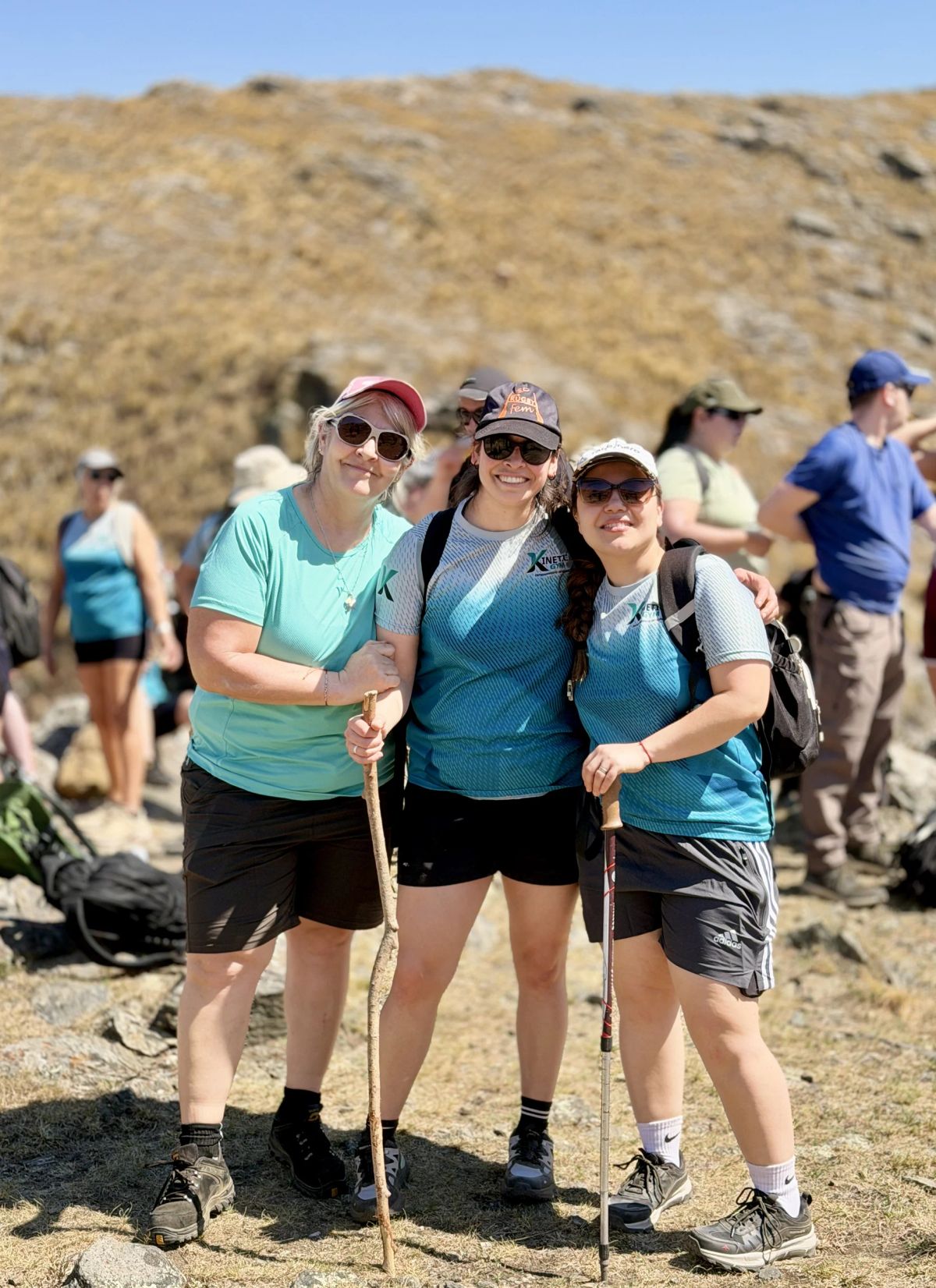 Grupo de trekkers posando con el pastizal de la Sierra de Comechingones de fondo