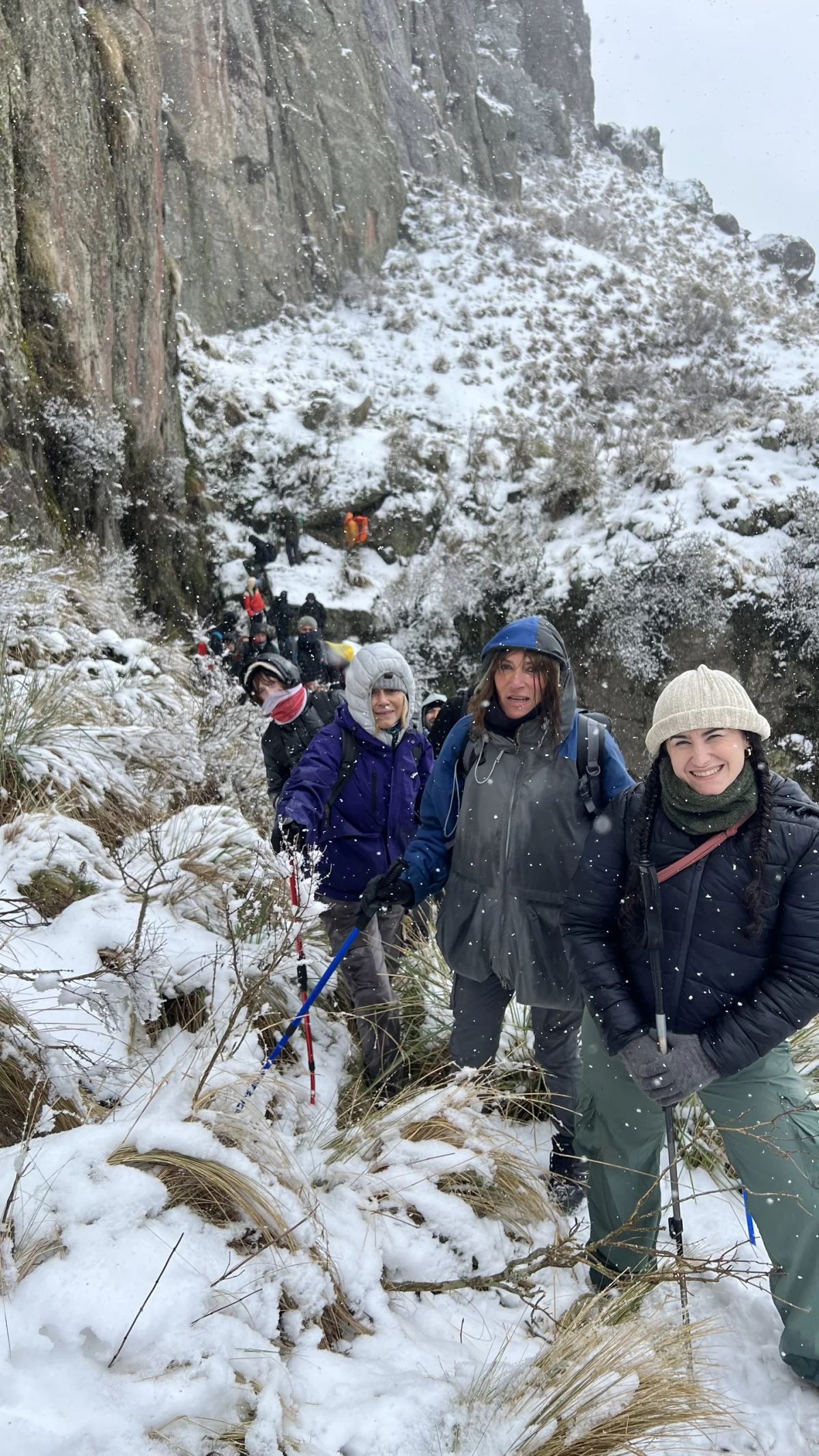 Grupo avanzando en fila por la quebrada nevada entre paredes de granito