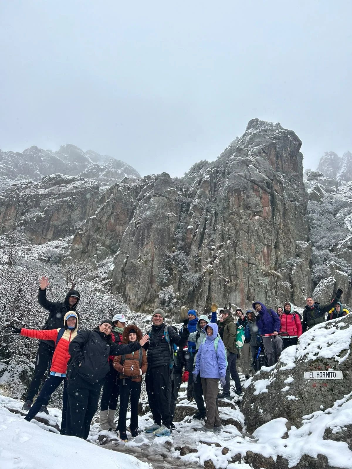El grupo de la Salida 210 saludando frente a las agujas de granito nevadas de Los Gigantes