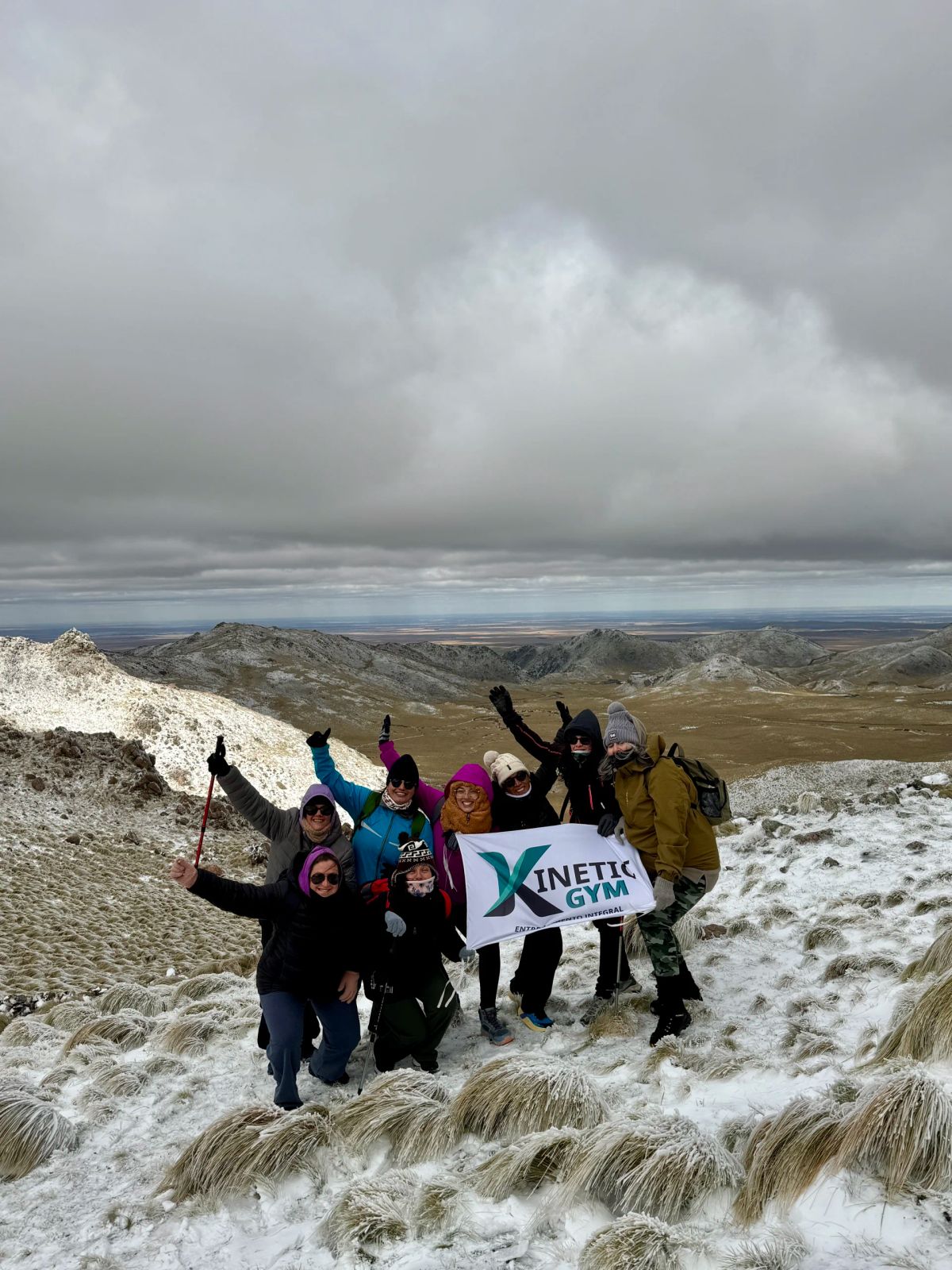 Festejo grupal con bandera en la cumbre nevada del Cerro El Morro, San Luis