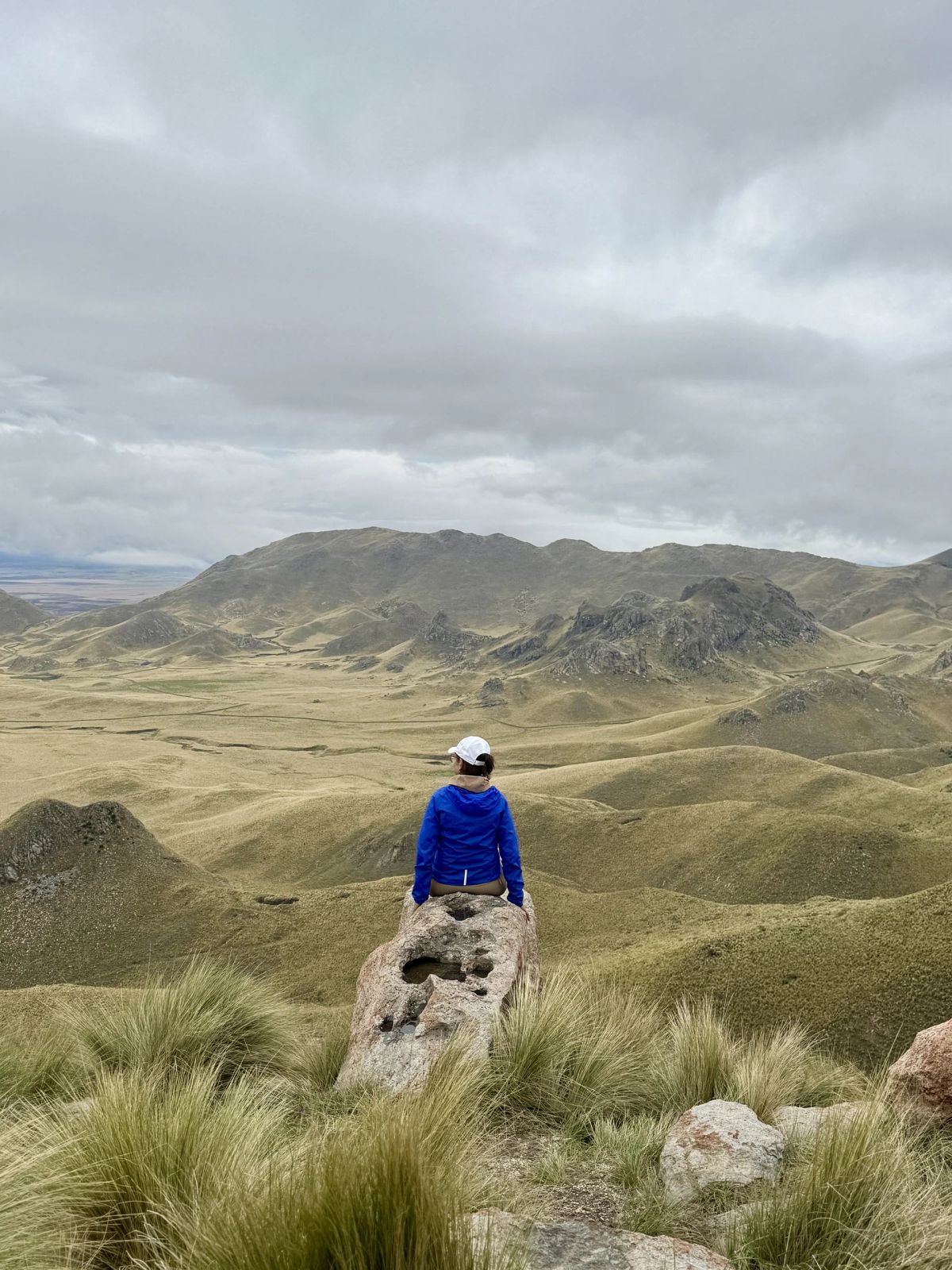 Caminante de pie sobre una roca con el valle interior del Morro detrás