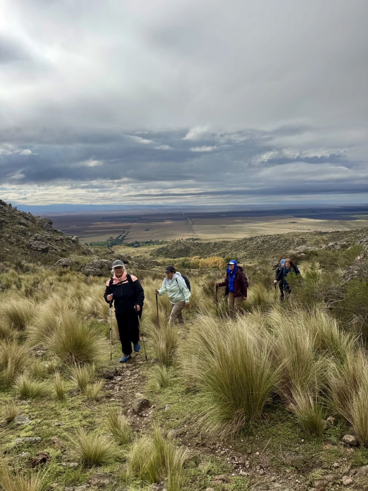 Trekkers de Mons remontando el pastizal con la llanura de San Luis al fondo