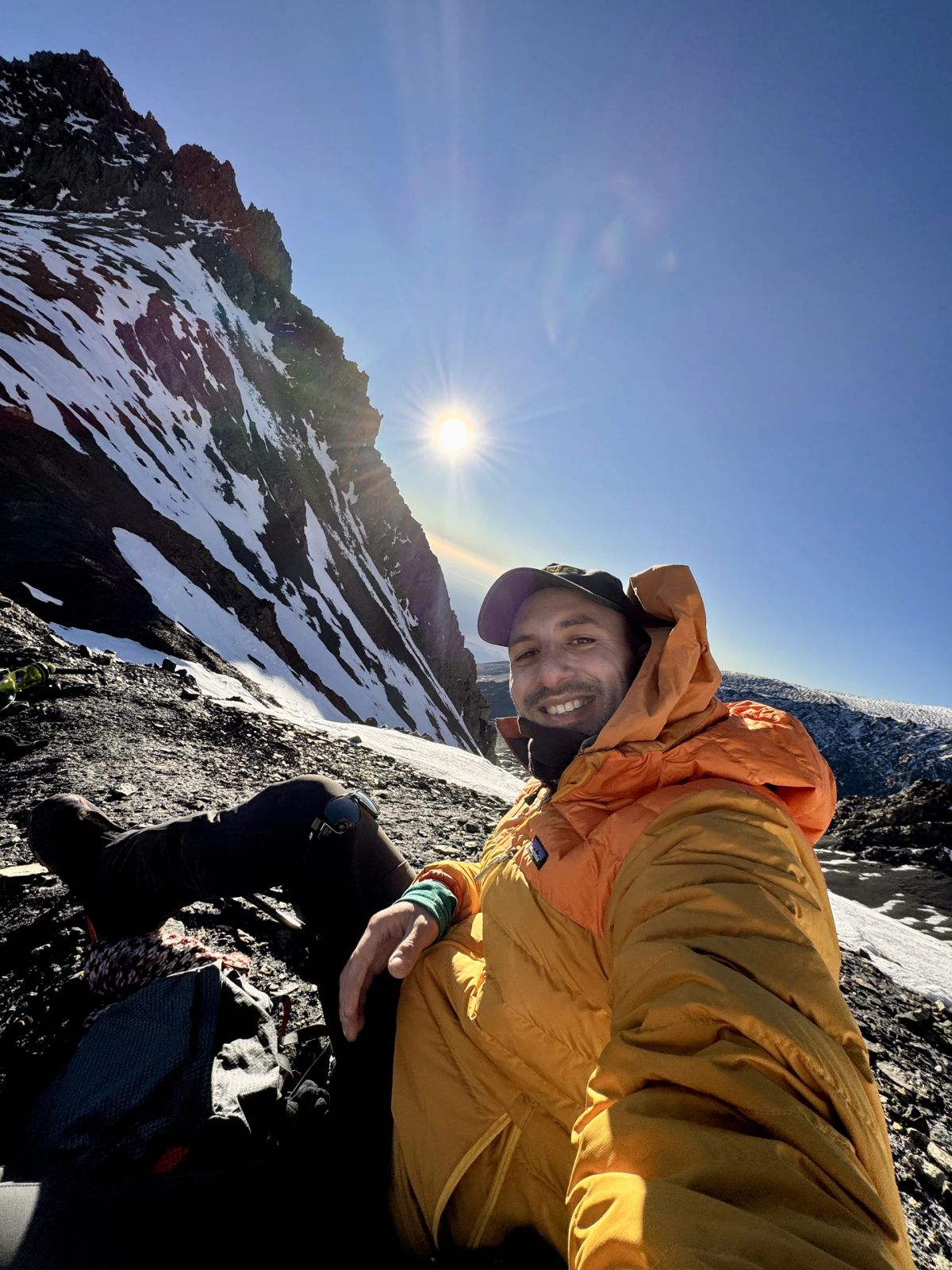 Selfie de dos andinistas con el sol naciente sobre las cumbres nevadas