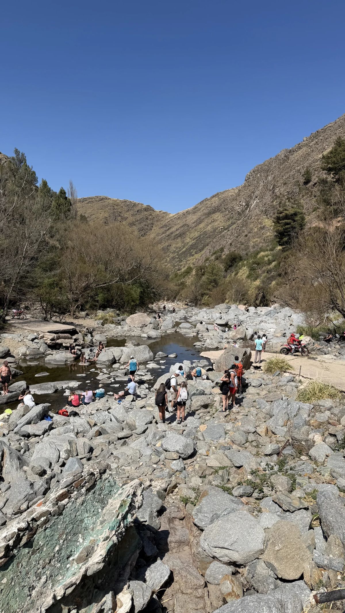 El cauce de piedras del arroyo en la quebrada, con el grupo repartido entre las rocas