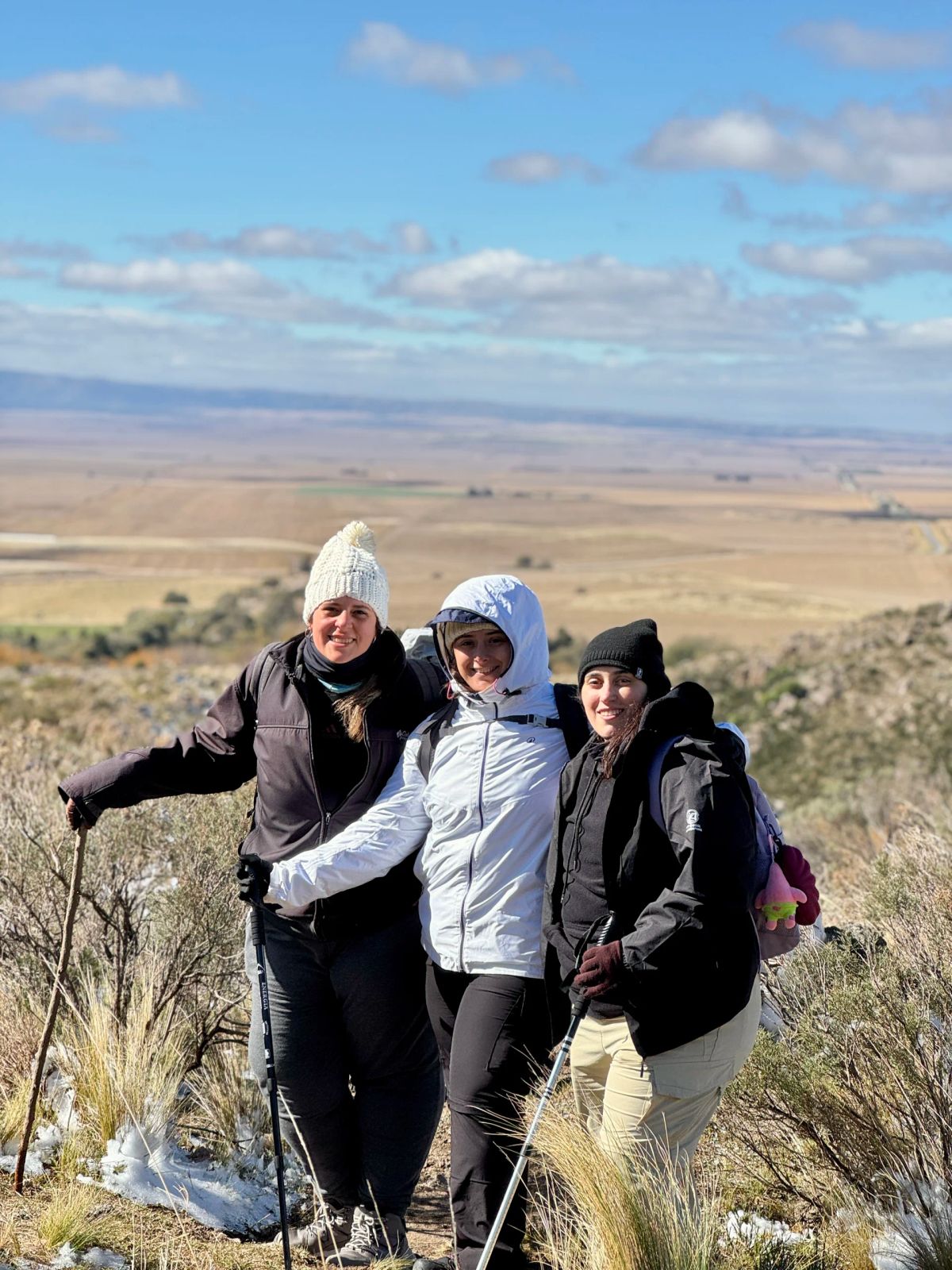Tres participantes de la Salida 206 posando con la llanura de San Luis de fondo