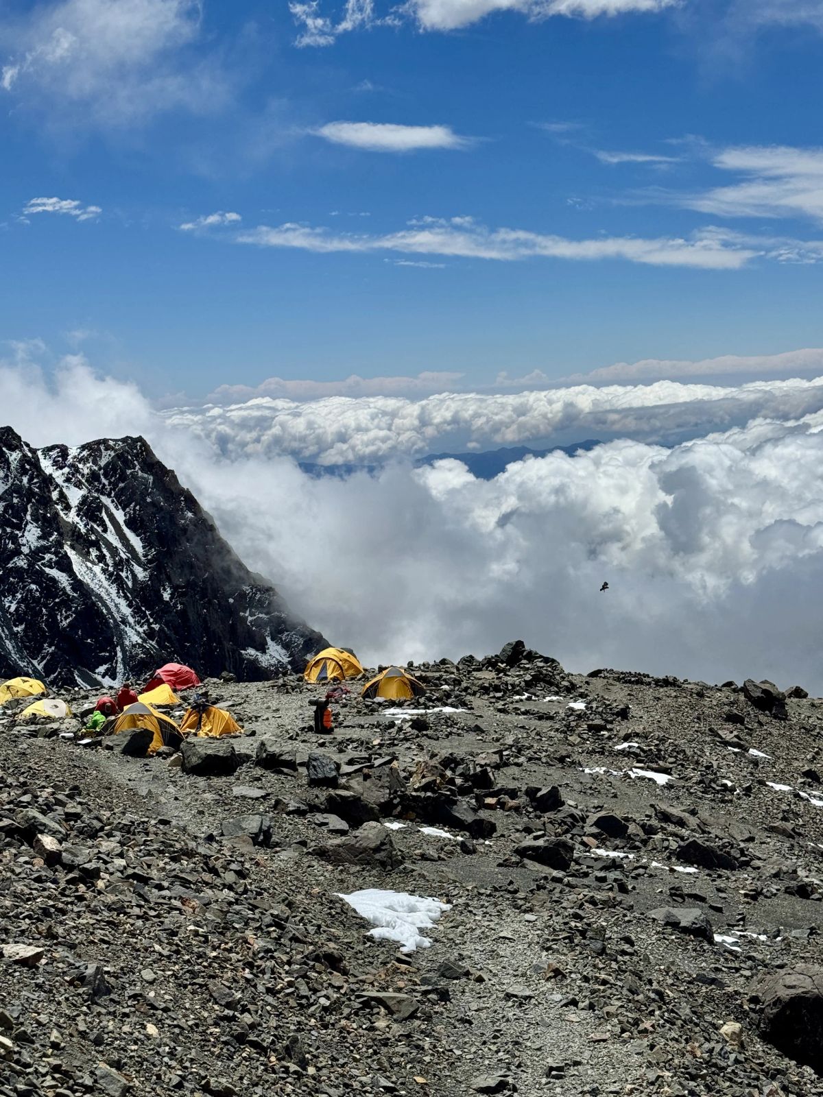 Las carpas amarillas del campamento con el mar de nubes cubriendo el valle