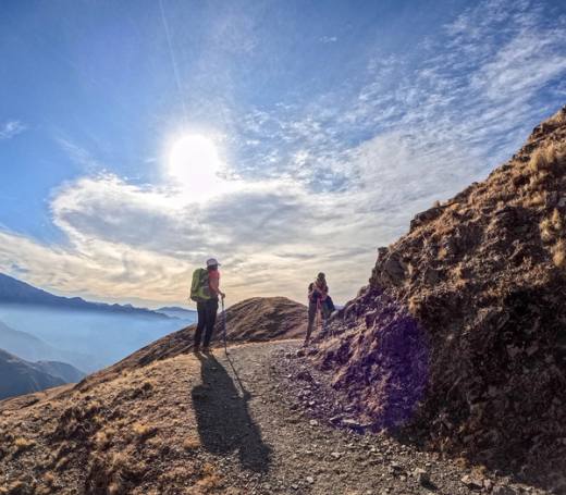Caminantes a contraluz sobre el filo del cerro