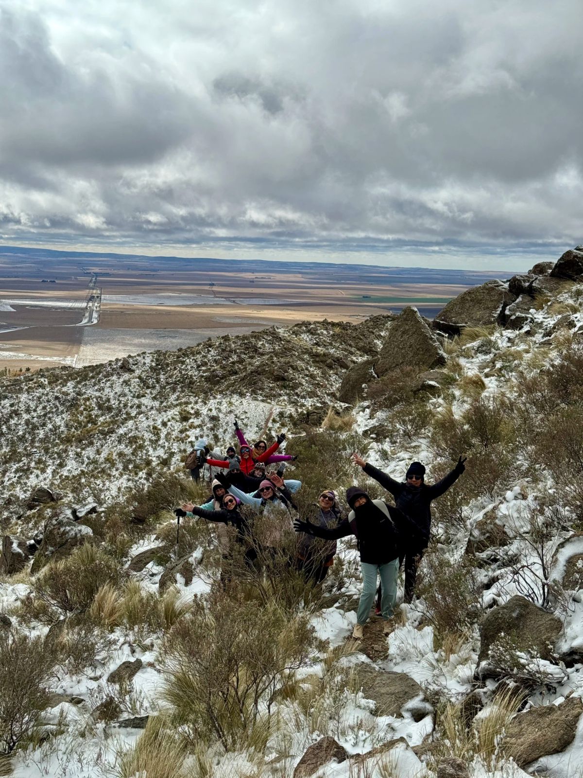 Participantes celebrando con los brazos en alto entre los pajonales nevados del Morro
