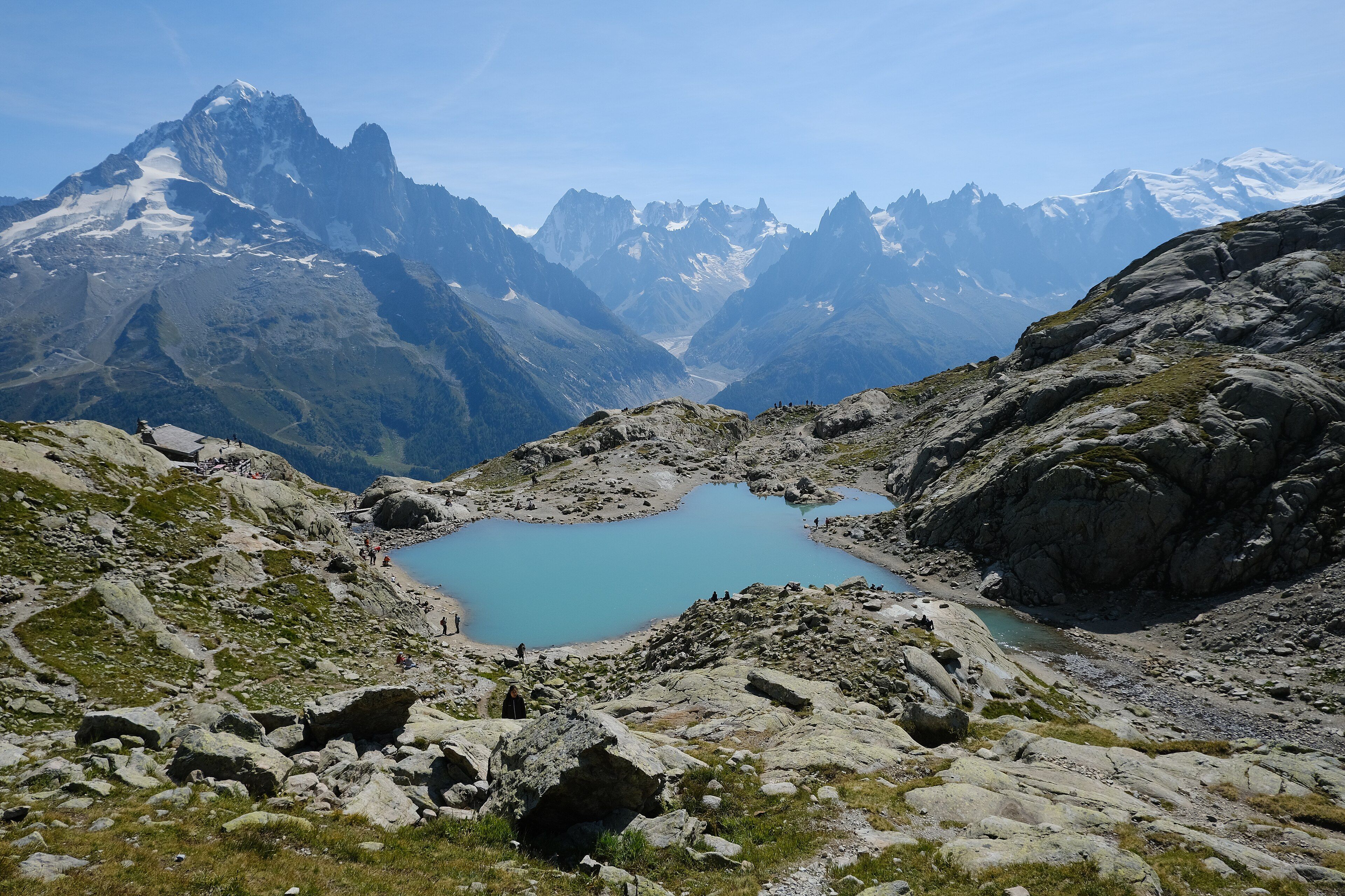 El Lac Blanc a 2.352 m, con caminantes en la orilla y la línea de agujas del macizo del Mont Blanc al fondo