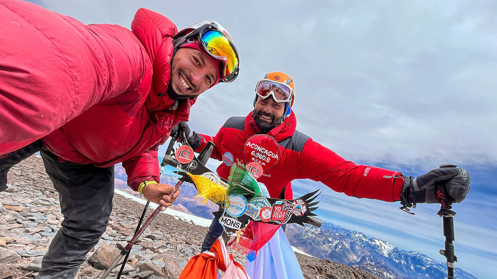 Grupo de personas felices con Camperas de pluma roja en Trekking cumbre de aconcagua 