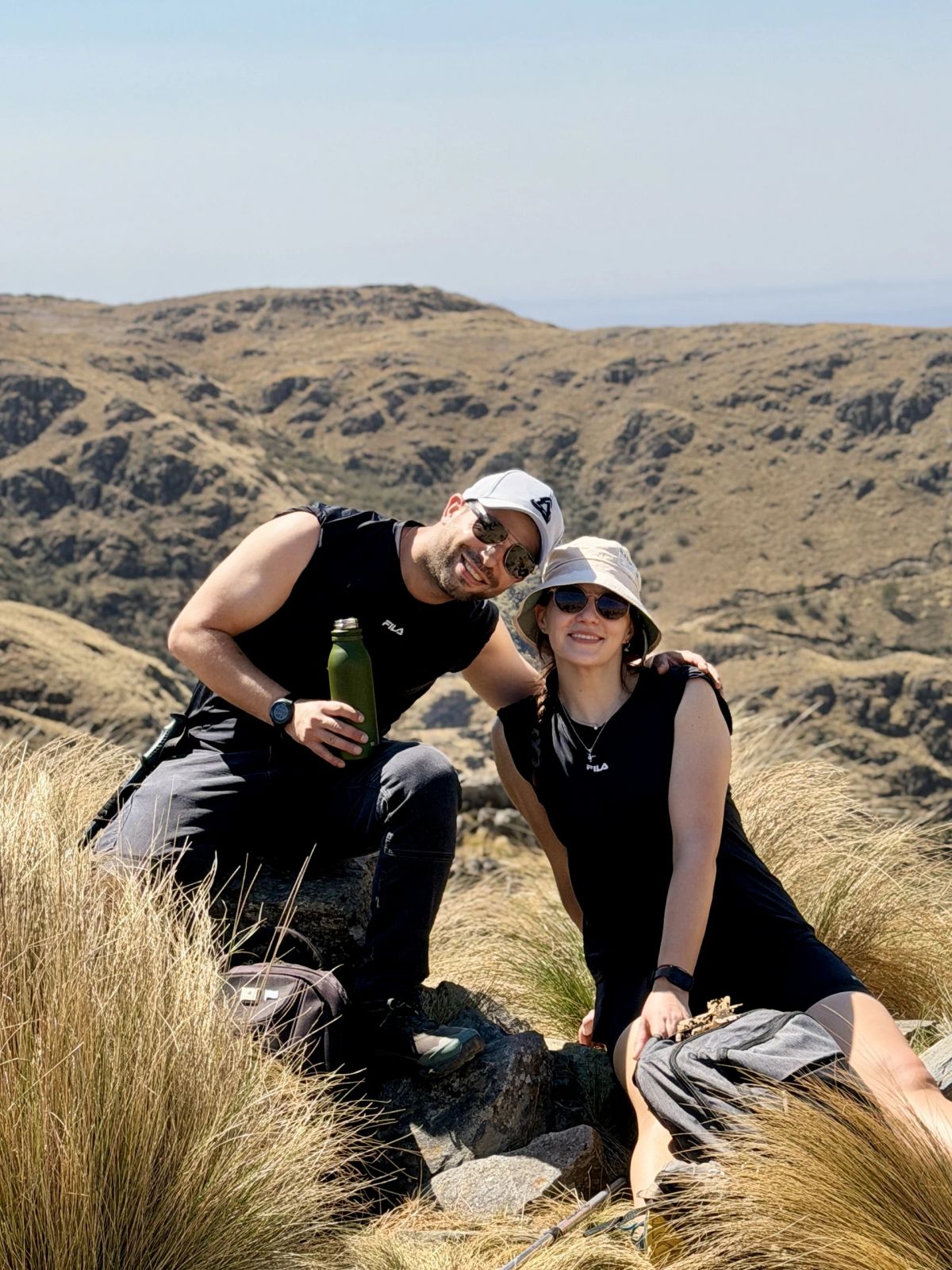 Participantes de Mons descansando sobre las rocas con vista a la sierra